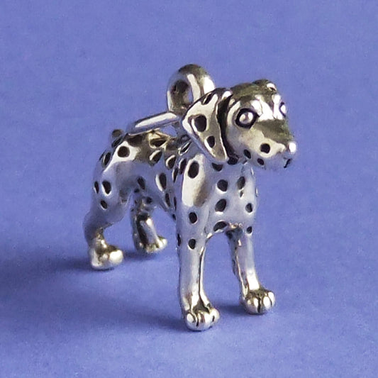 sterling silver Dalmatian dog charm on a purple background