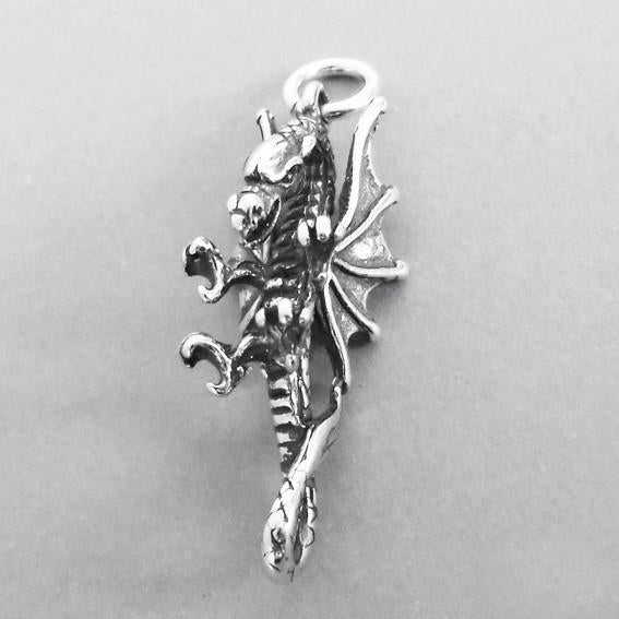 silver dragon charm on grey background