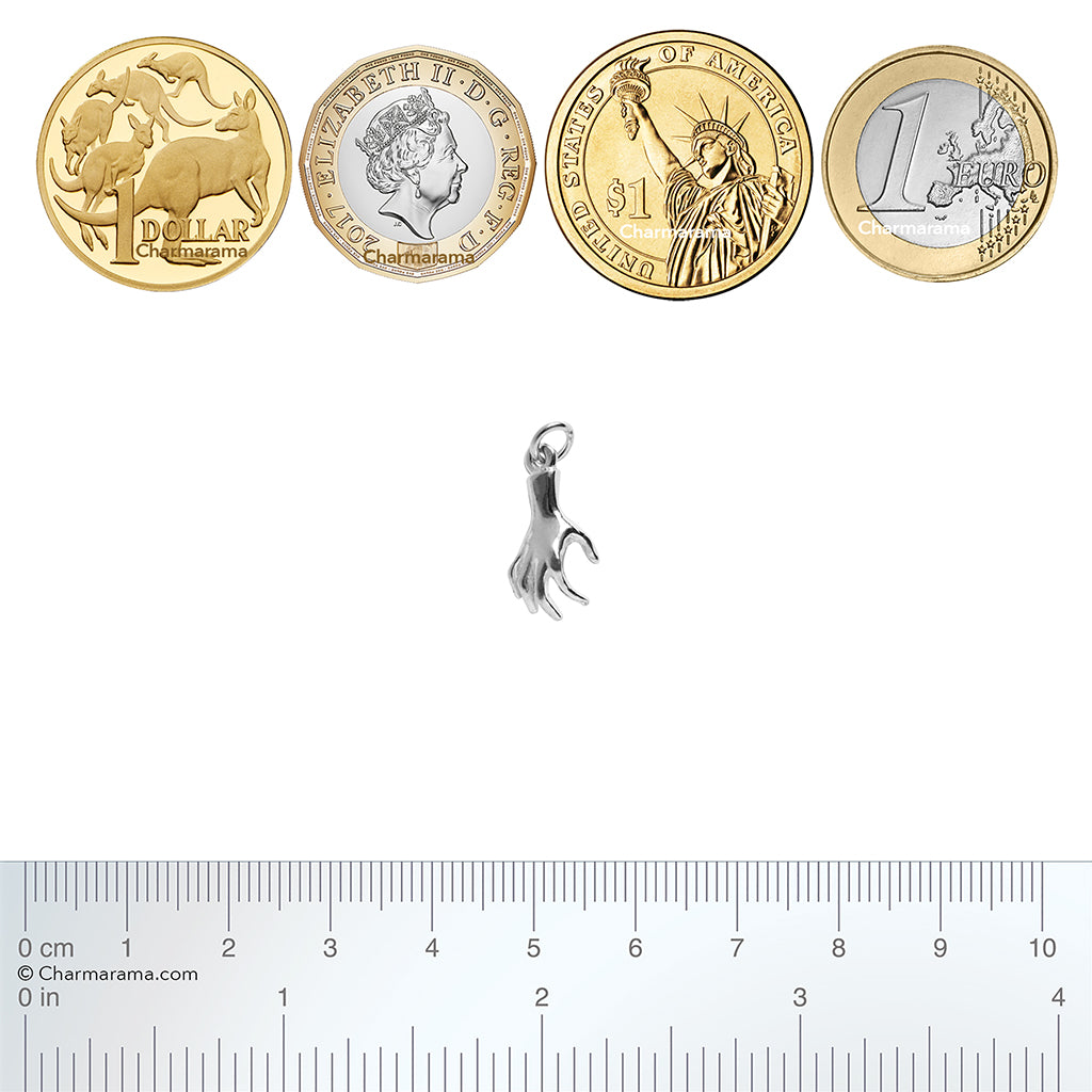 silver human hand charm with coins and ruler for scale