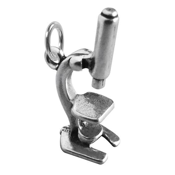 silver microscope charm on white background