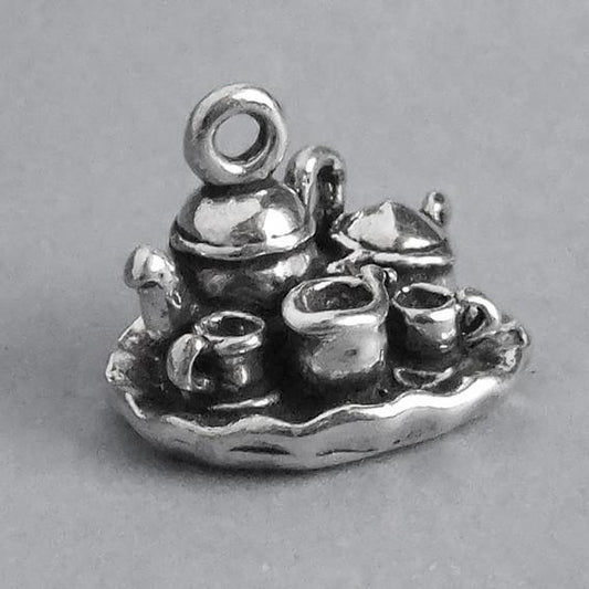 silver tea set charm on grey background