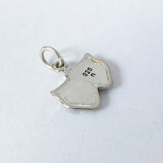 back view of silver theatre masks charm on grey background