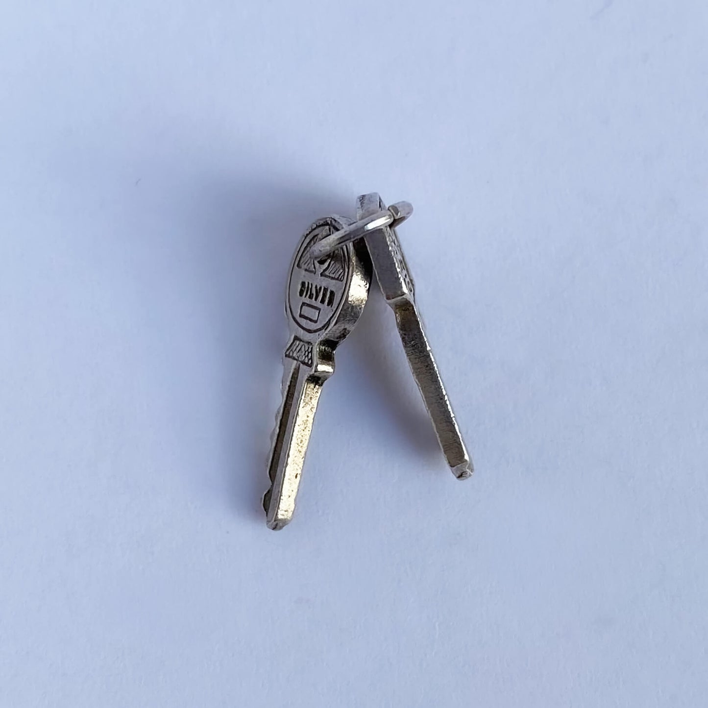 Nuvo vintage charm of two sterling silver keys on a white background