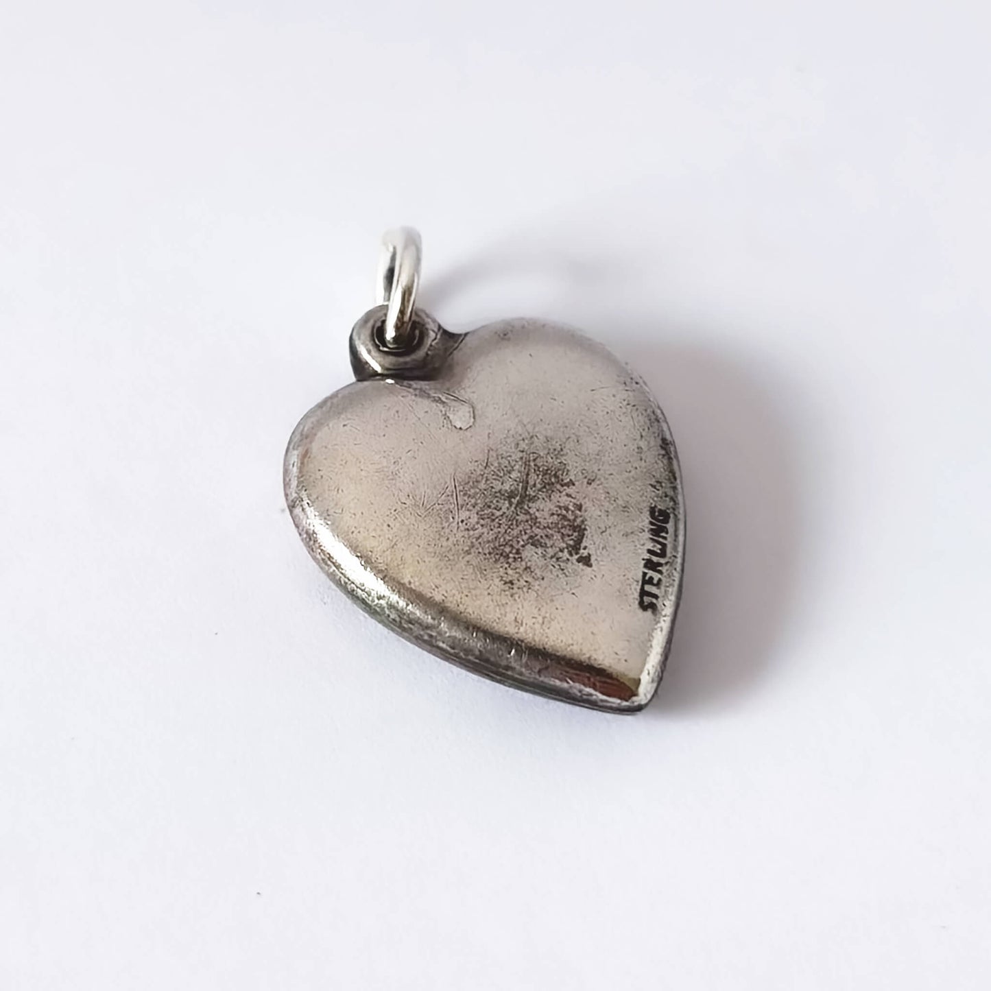 Silver heart-shaped pendant on a white background