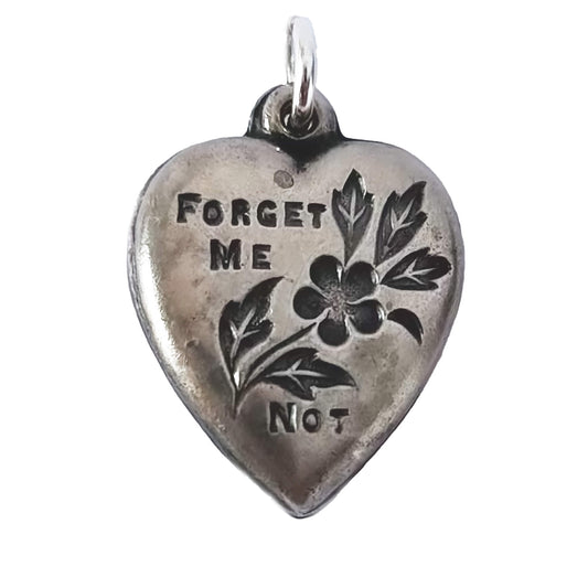 Silver heart-shaped pendant with 'Forget Me Not' engraving on a white background