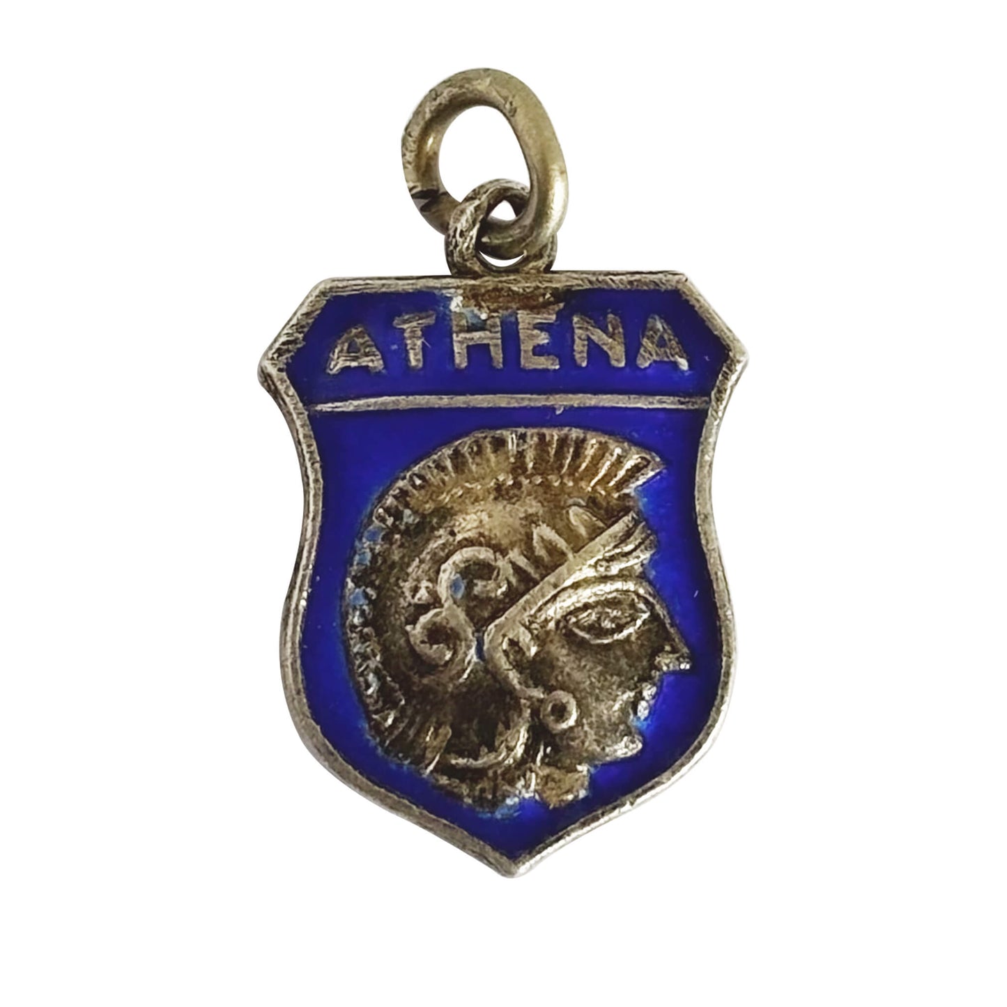 A vintage travel shield charm picturing the side view head of Goddess Athena on blue enamel on white background.