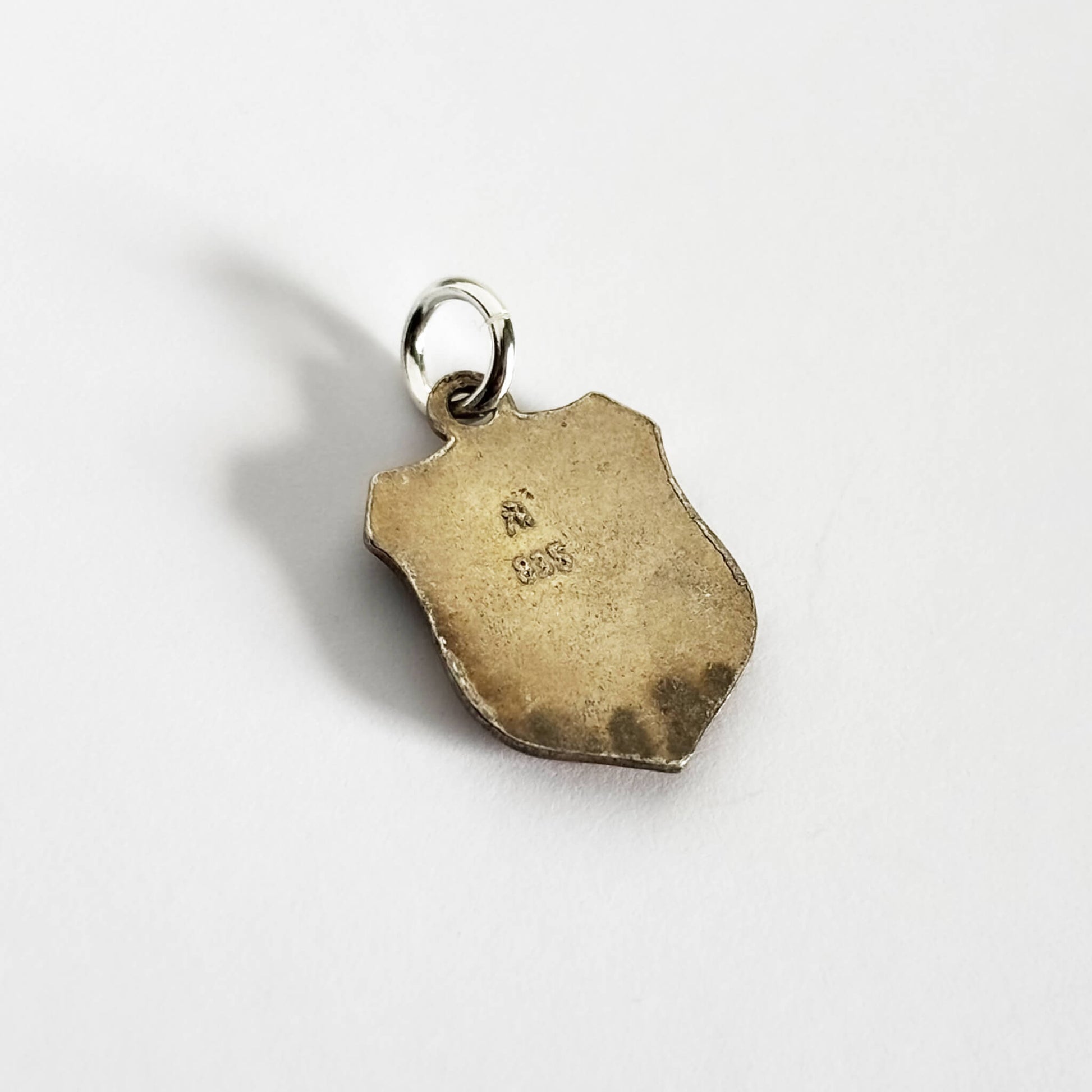 Reverse of vintage shield charm