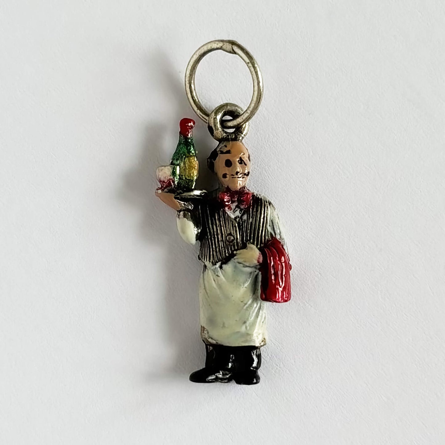 A vintage 1950s wine waiter sommelier charm or pendant, silver with enamel details