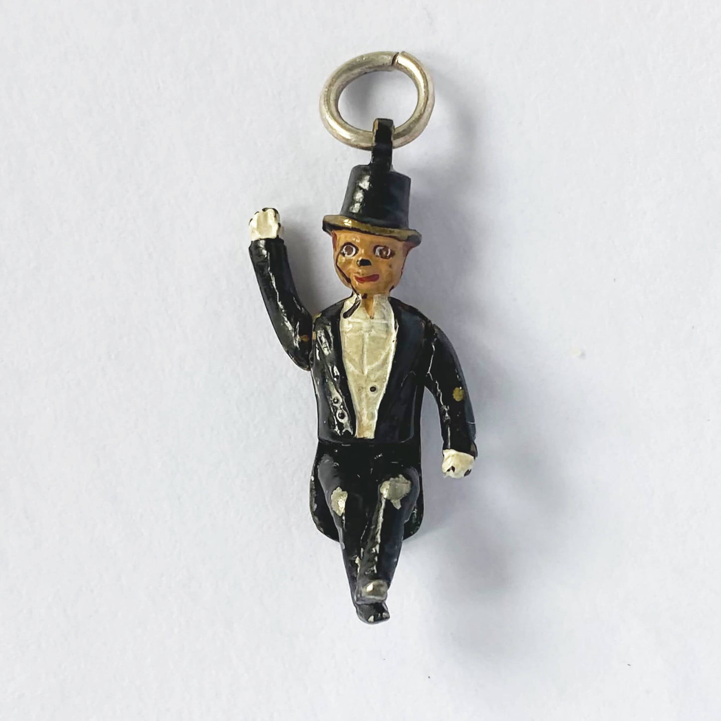 Small figurine of a man in a suit and top hat on a white background