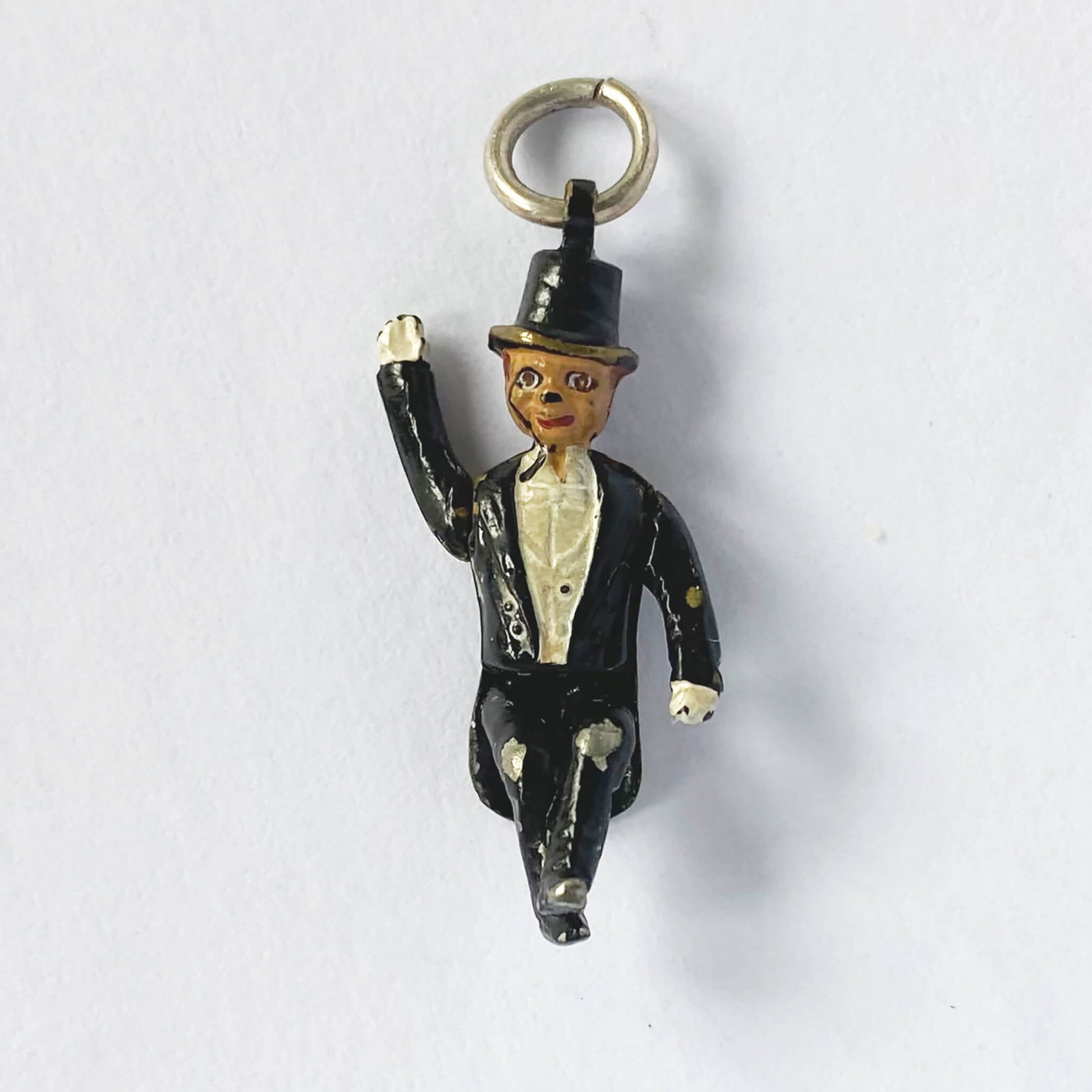 Small figurine of a man in a suit and top hat on a white background
