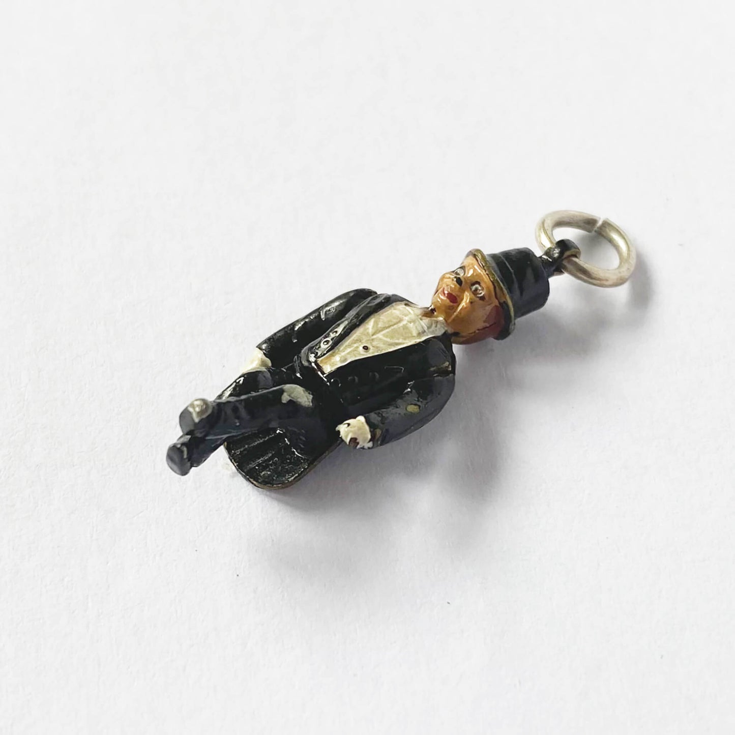 Vintage pendant of a figure in formal attire on a white background