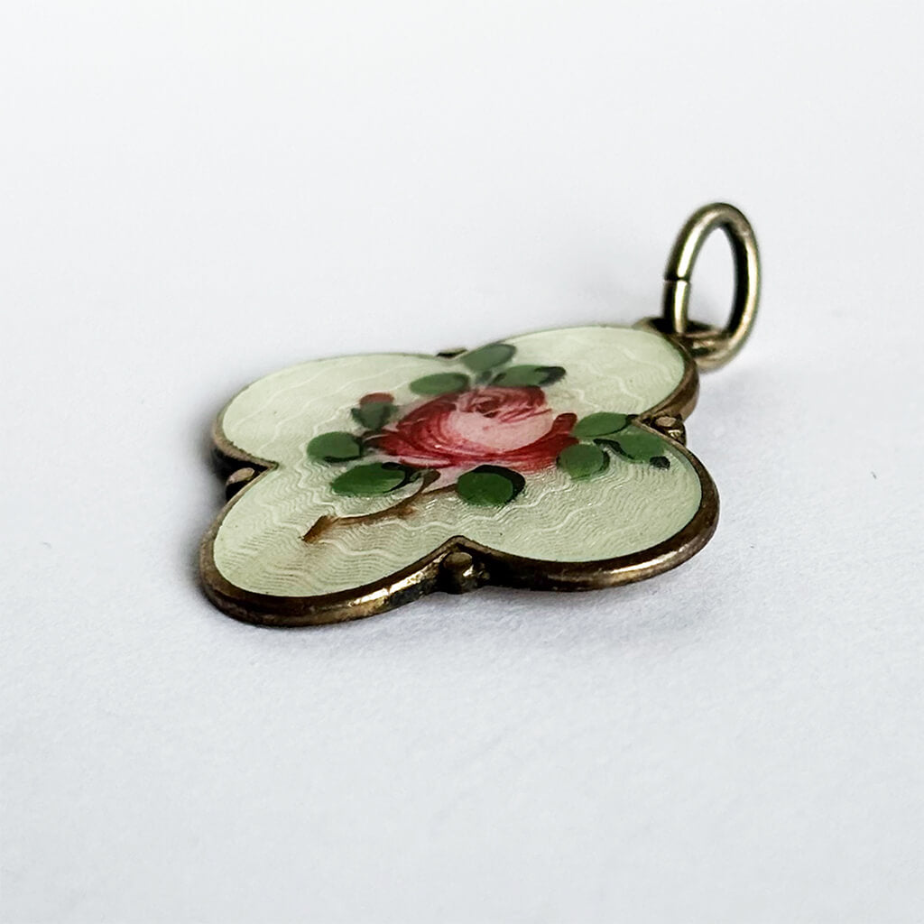 Norwegian quatrefoil pendant with a rose design on a white background