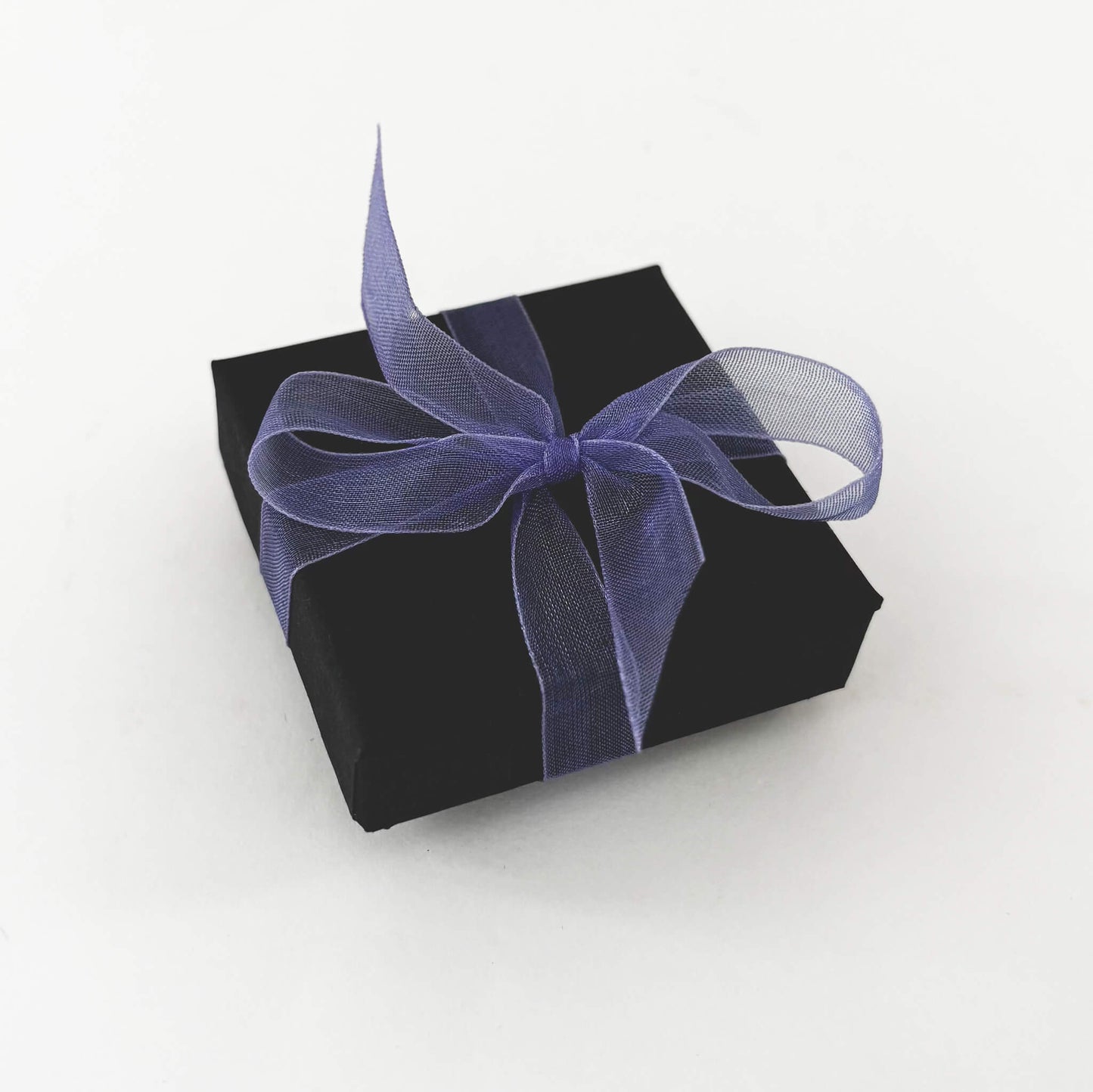 Black gift box with a purple ribbon on a white background