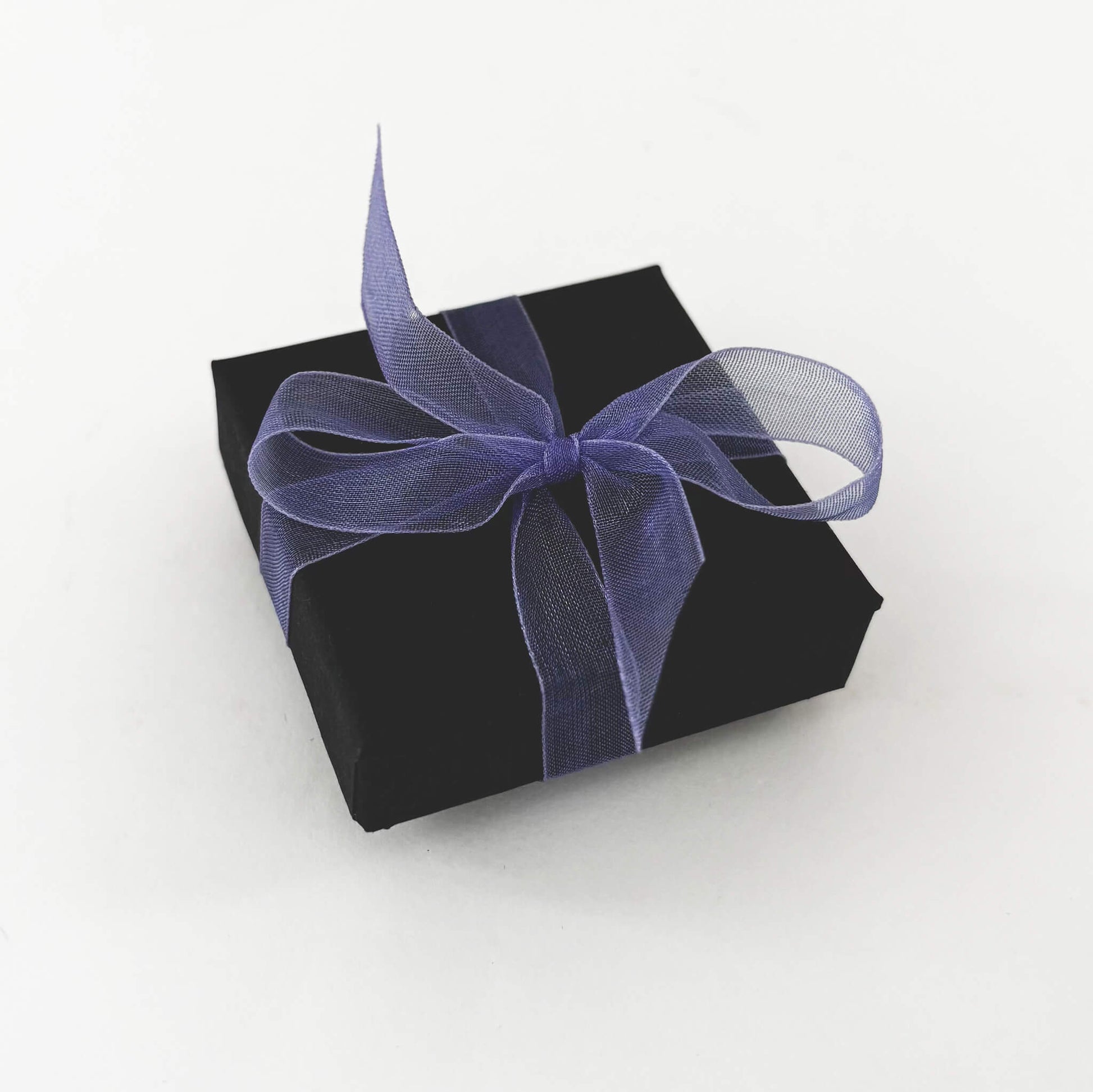 Black gift box with a purple ribbon on a white background