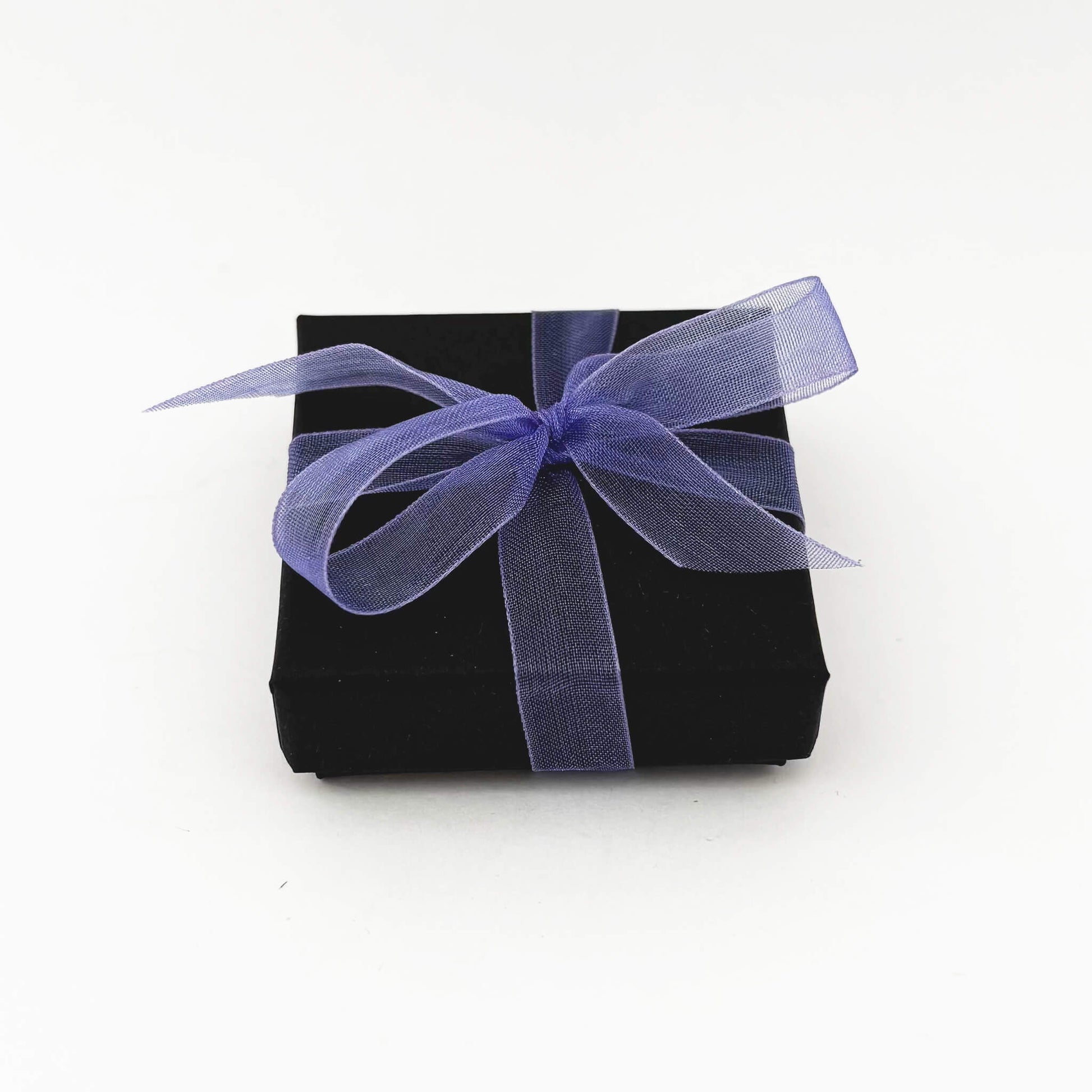 Black gift box with a purple ribbon on a white background