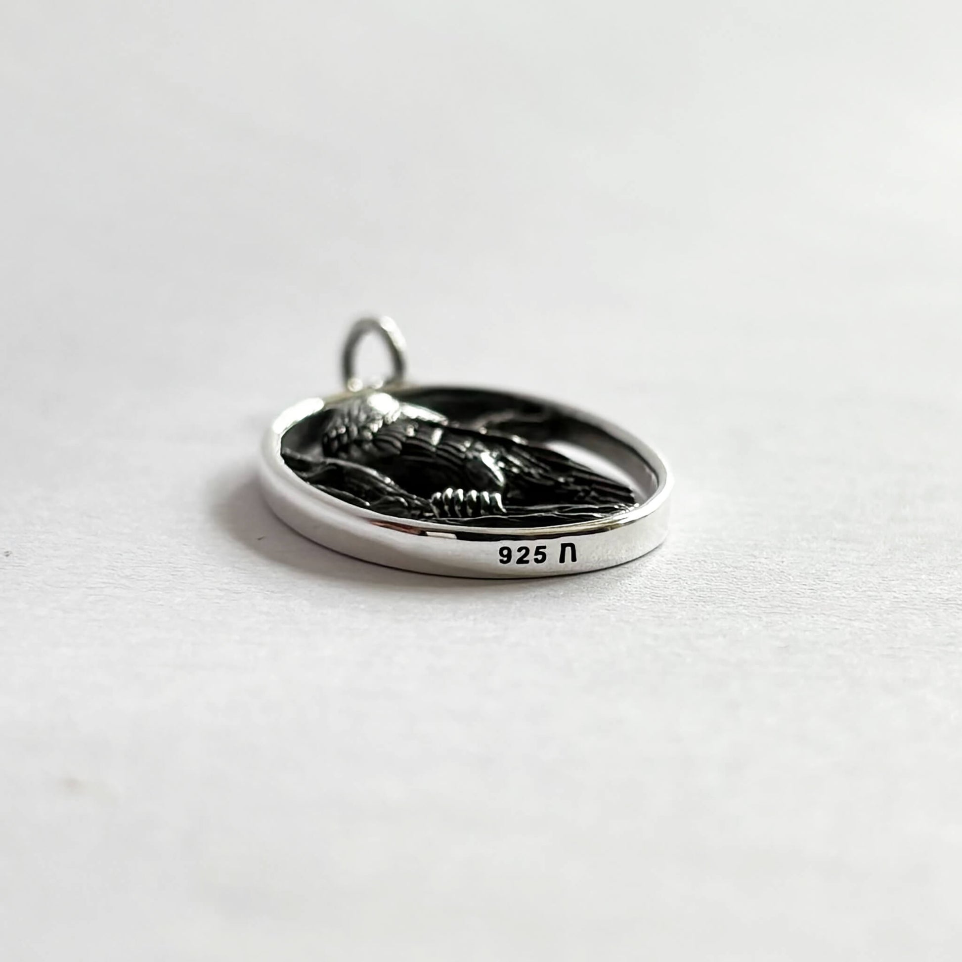 Crow in oval frame charm sterling silver bird pendant side view