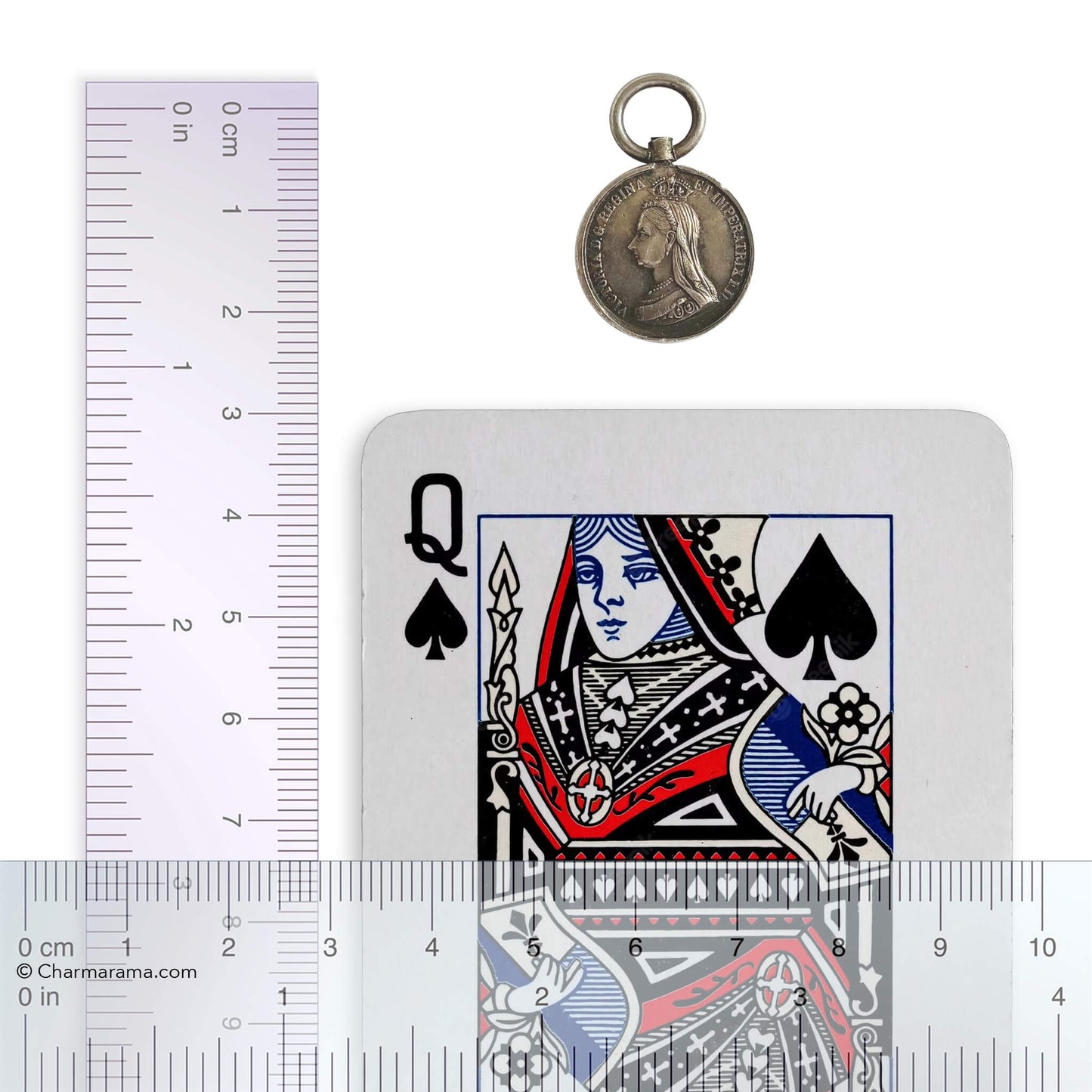 Victorian fob with a playing card and ruler for scale on a white background