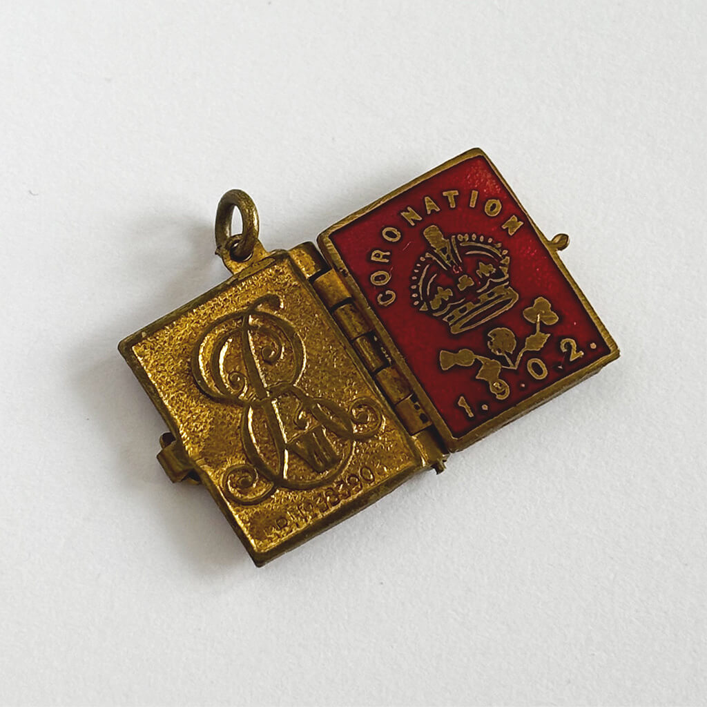 1902 Coronation photo album charm open showing front and back cover on white background