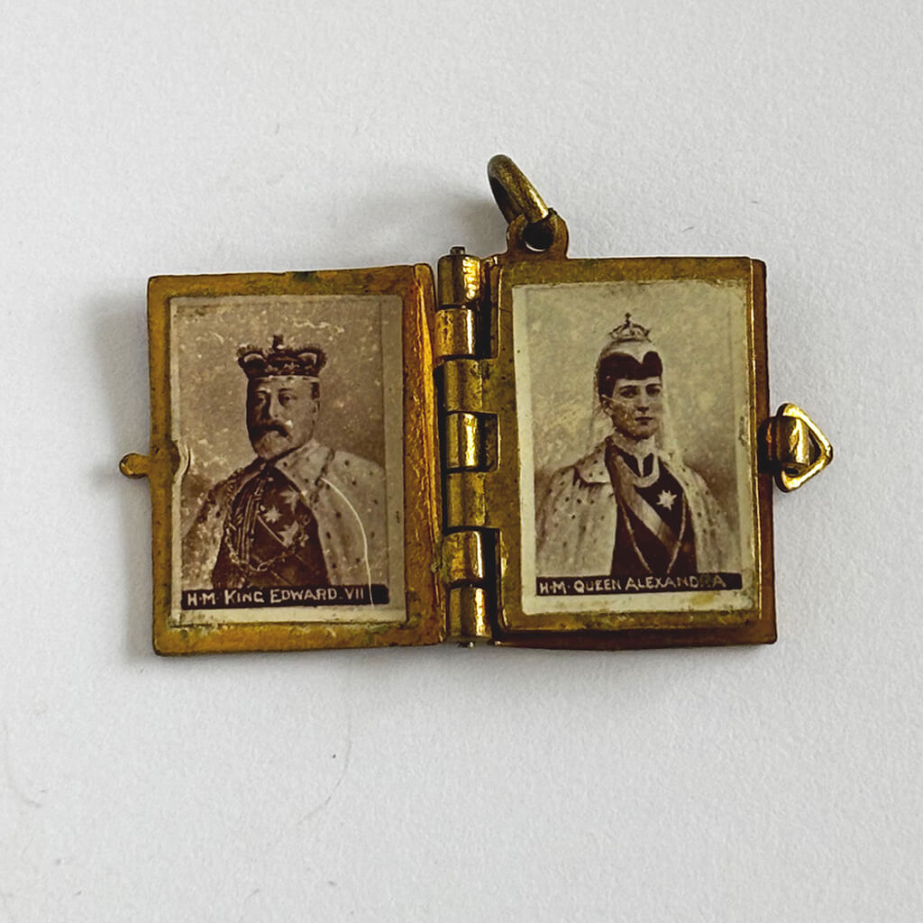 1902 Coronation photo album charm open to King Edward and Queen Alexandra on white background