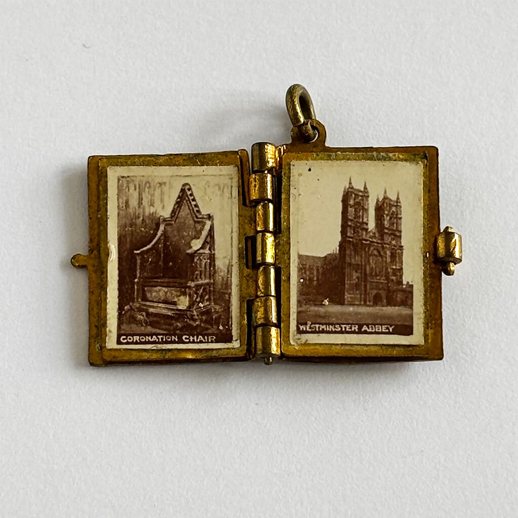 1902 Coronation photo album charm open to Westminster Abbey on white background