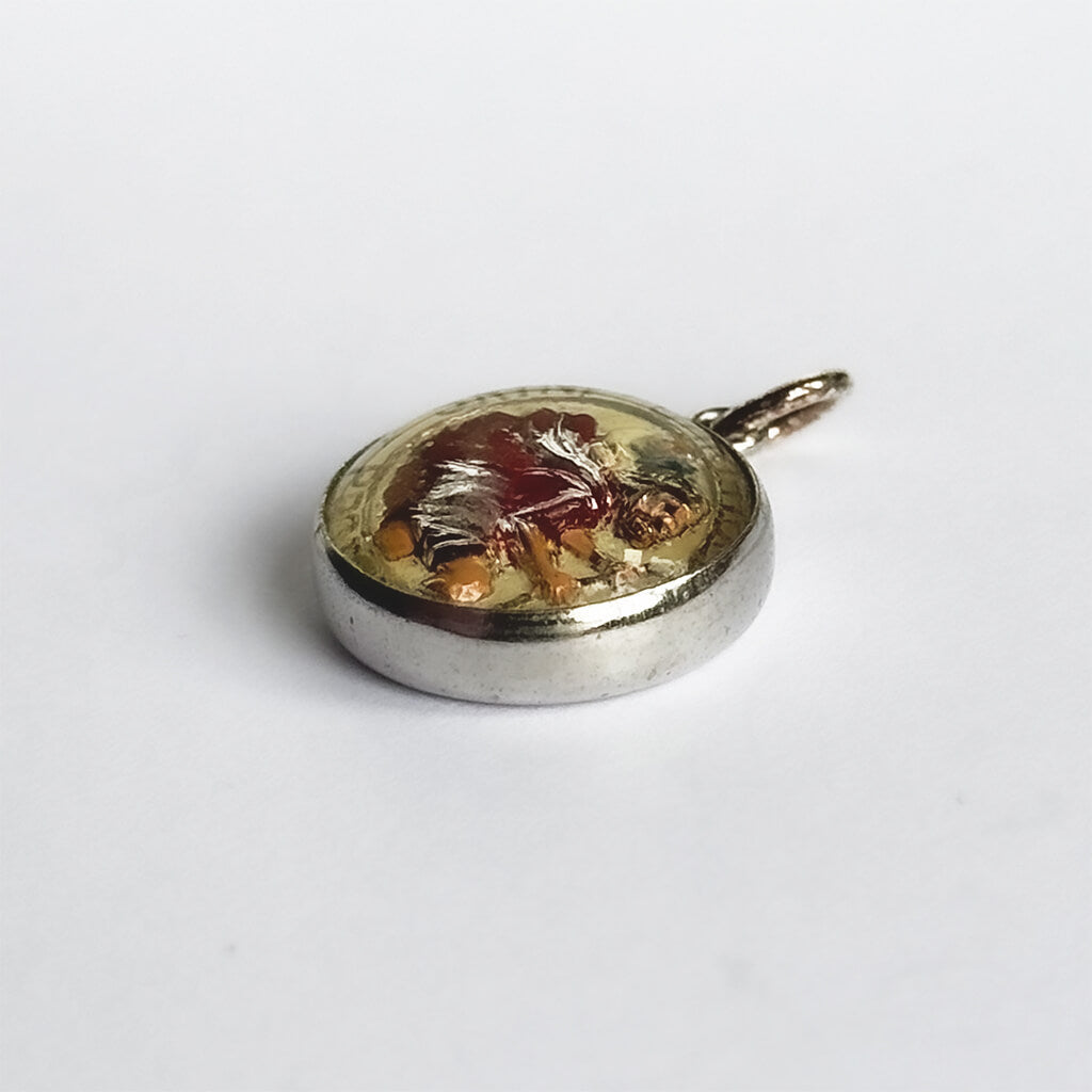 A vintage reverse crystal Saint Christopher charm on a white background