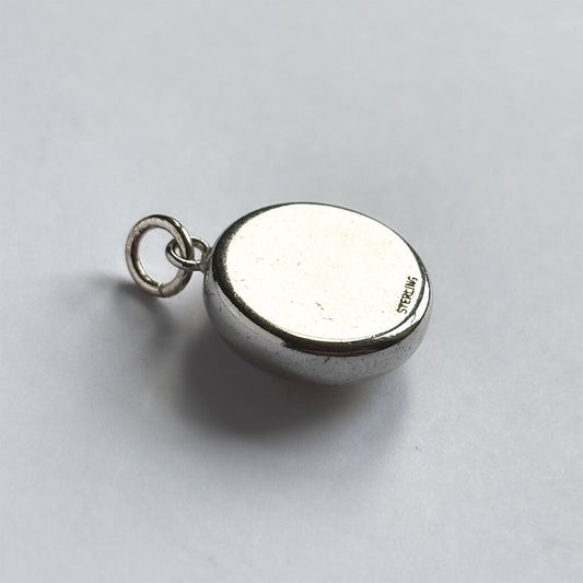 Back of a vintage reverse crystal charm on a white background