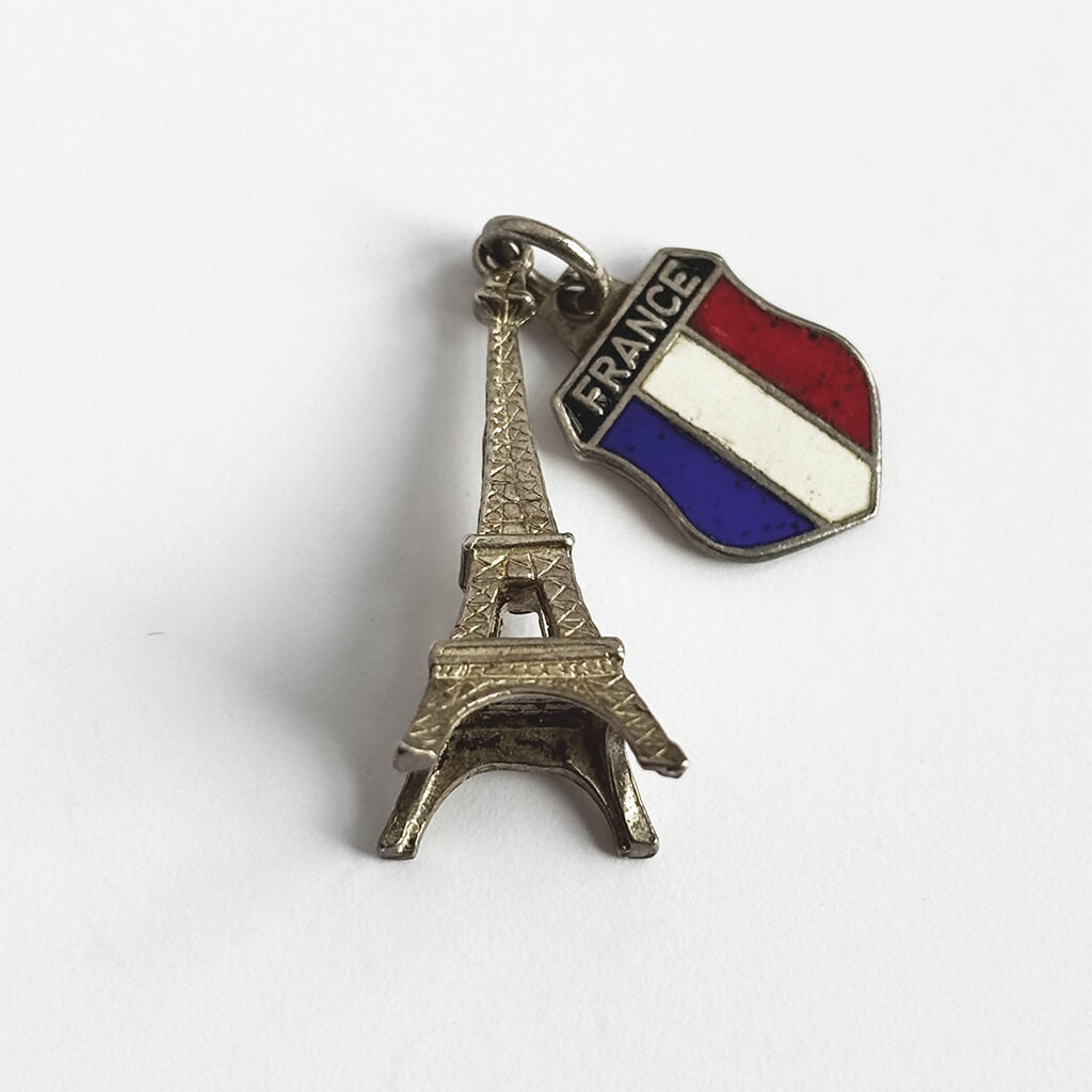 Silver charm with Eiffel Tower design and French flag on a white background