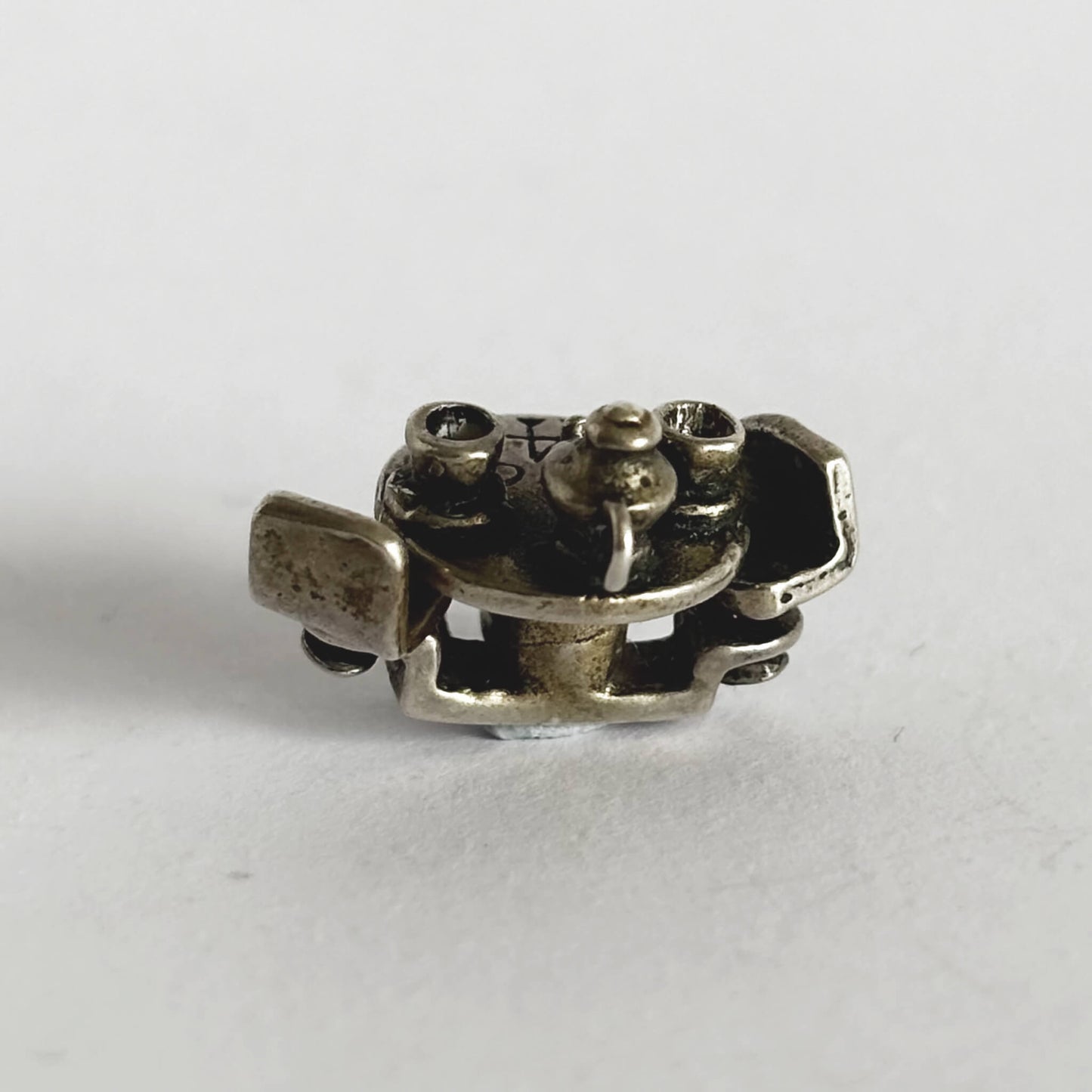 silver cafe table with teacups and teapot charm on a white background