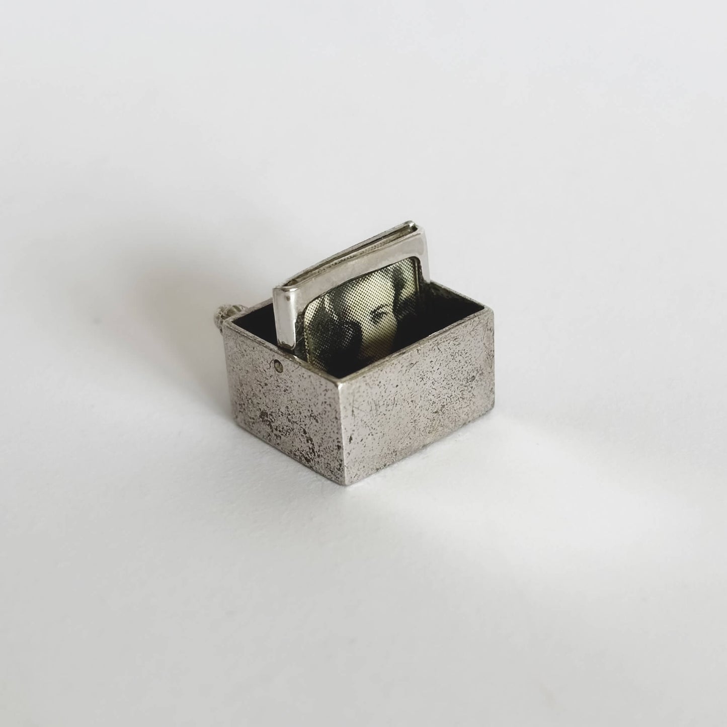 silver TV charm with turning screen on a white background