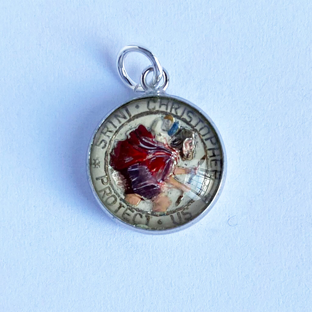 Round pendant with religious design on a light blue background