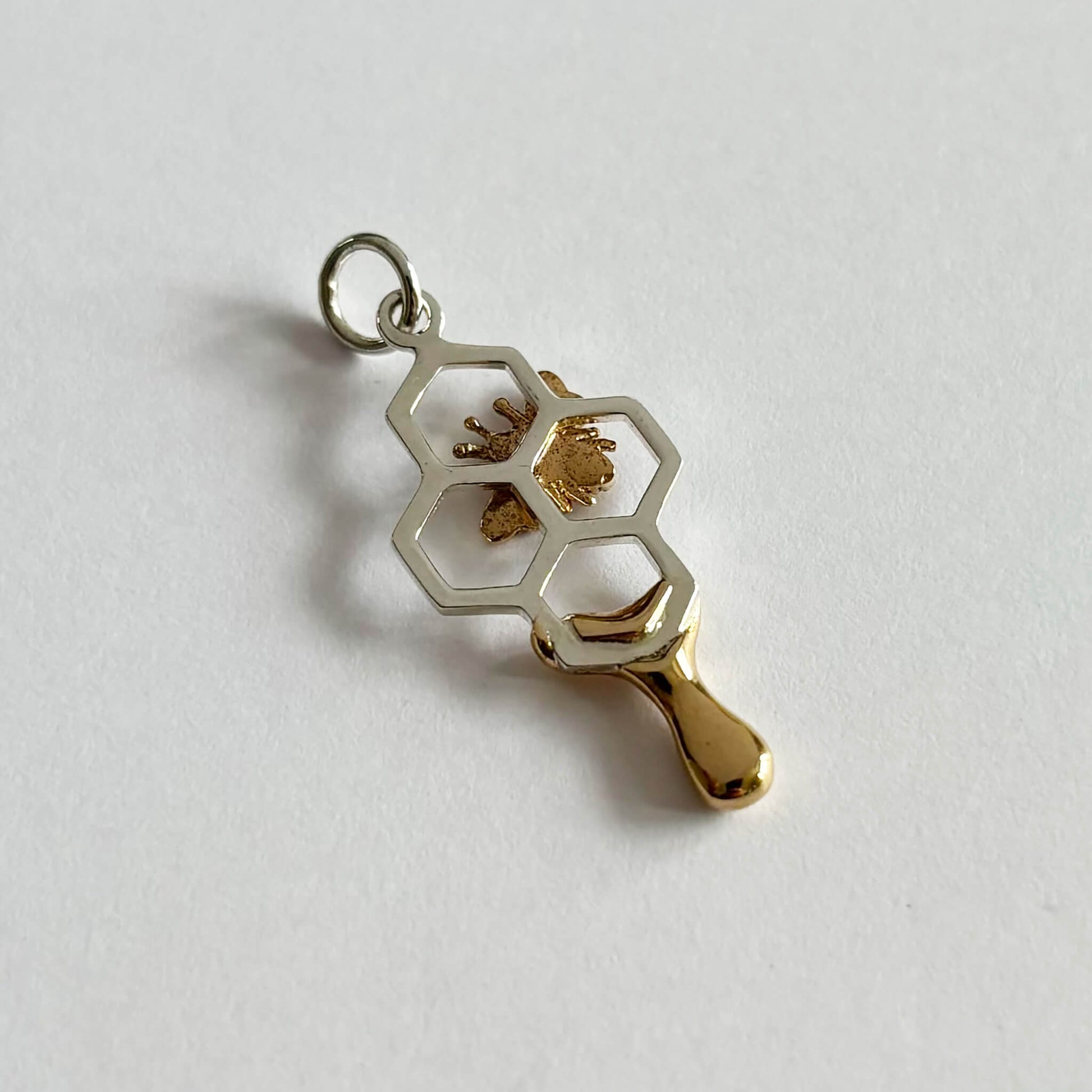 Honey bee on honeycomb charm in sterling silver and bronze