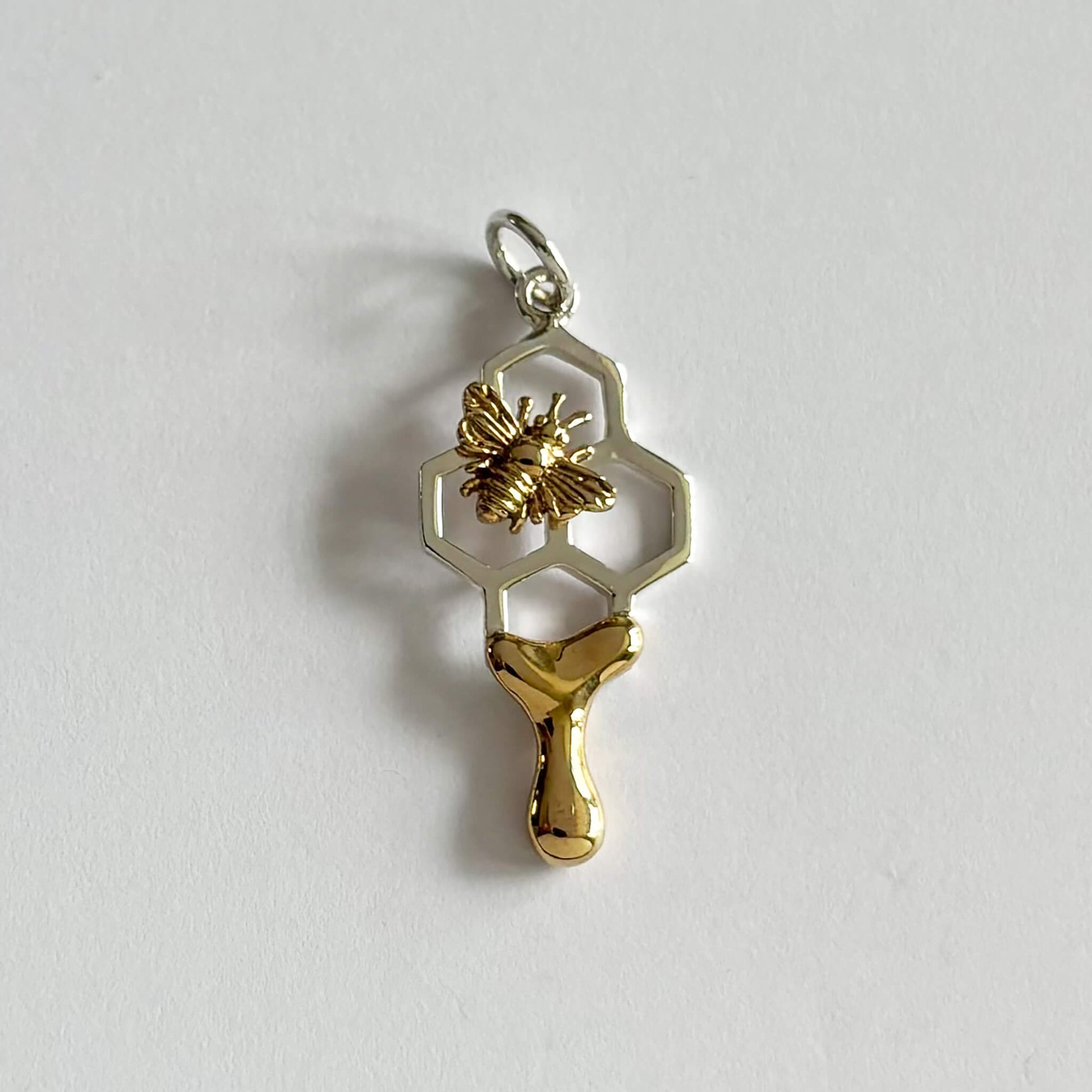 Honey bee on honeycomb charm in sterling silver and bronze
