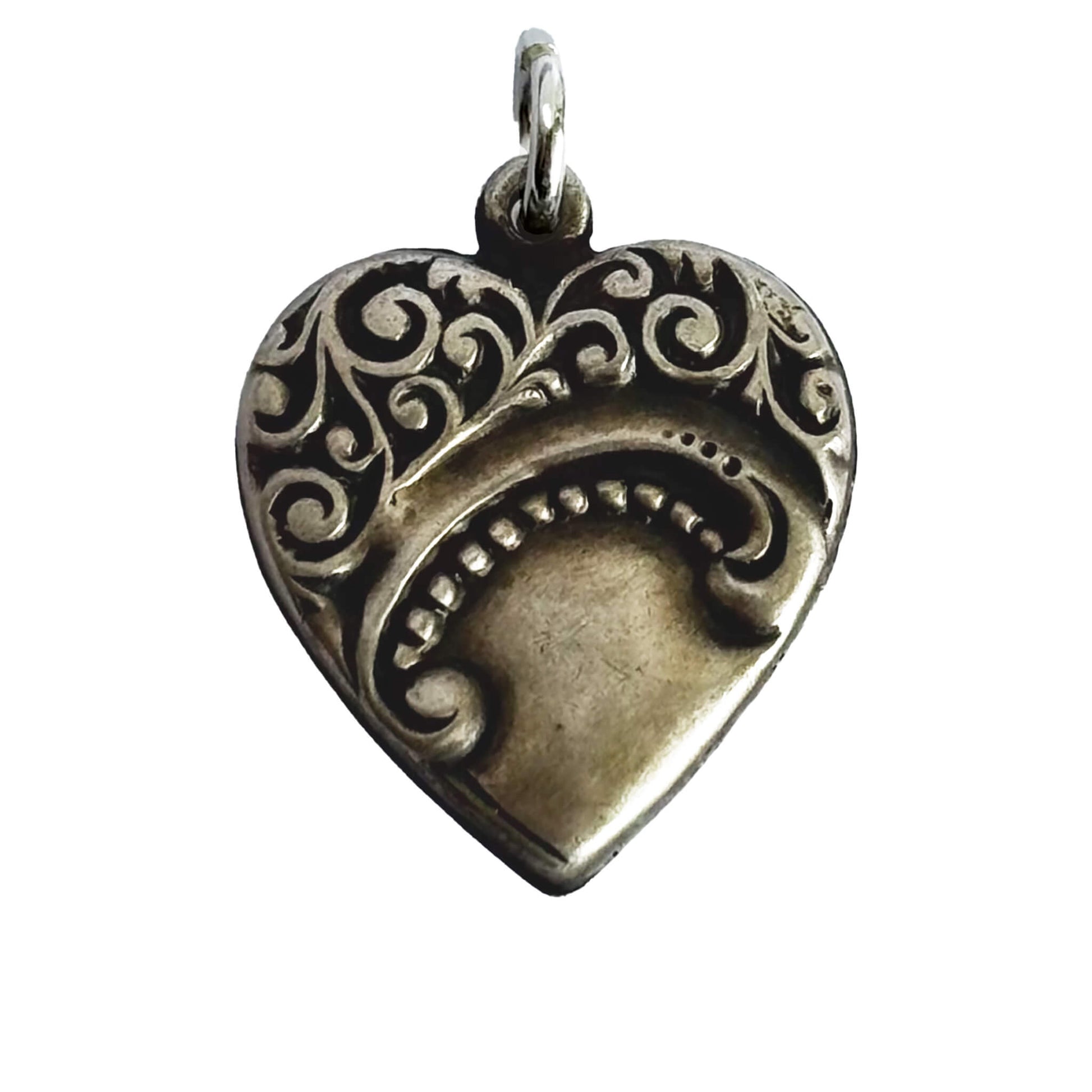 Silver heart-shaped pendant with intricate designs on a white background