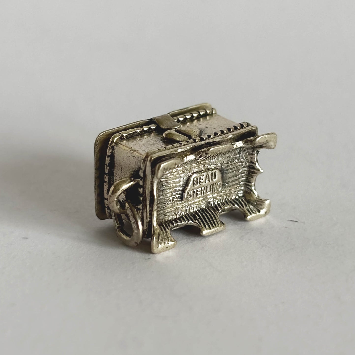 Underside of sterling silver hope chest charm on a white background