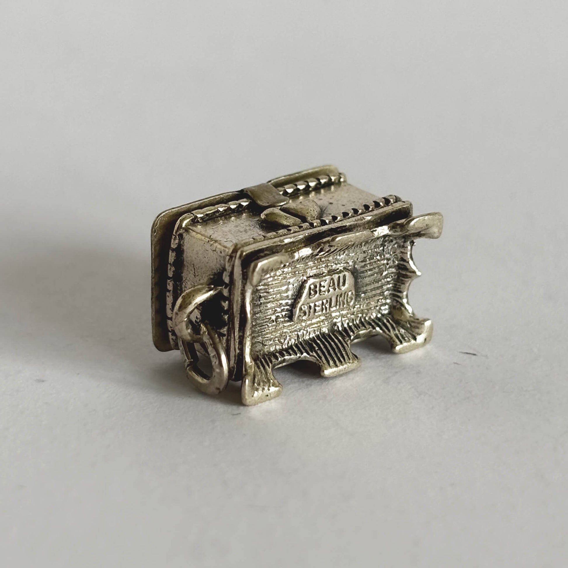 Underside of sterling silver hope chest charm on a white background