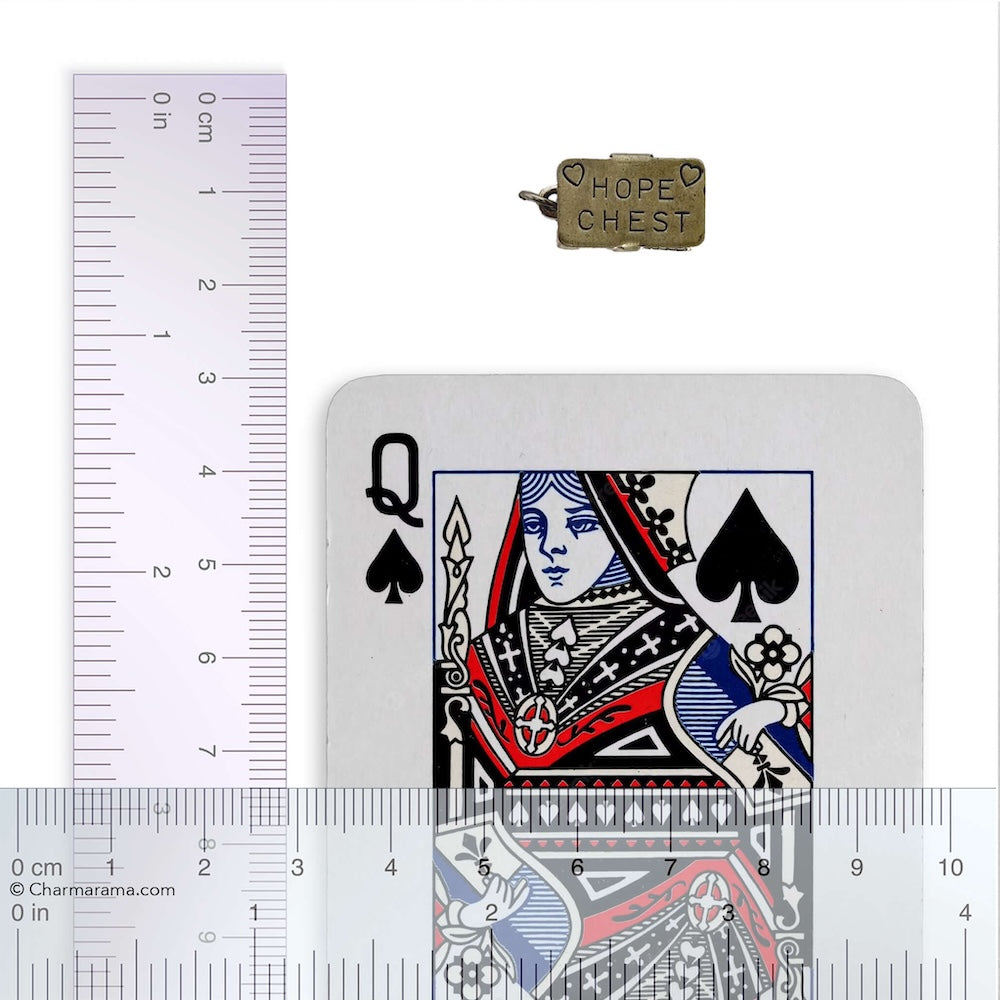 Sterling silver hope chest charm with playing card with ruler on a white background