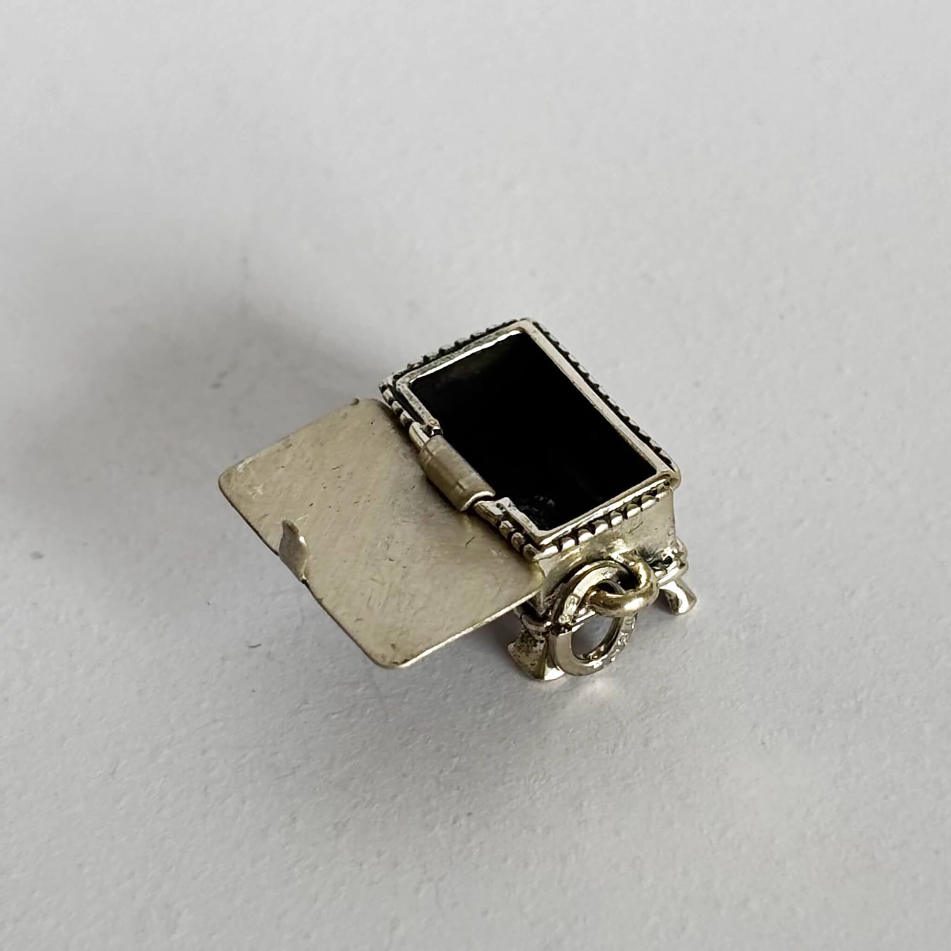 Sterling silver hope chest charm shown open on a light grey background
