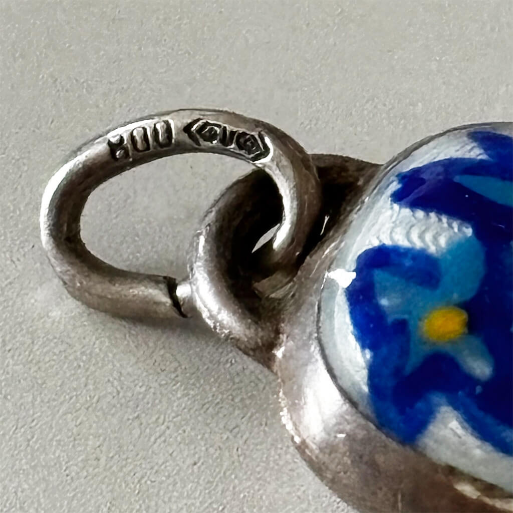 Vintage Silver Swiss Bell Charm with blue gentian flower on a white background