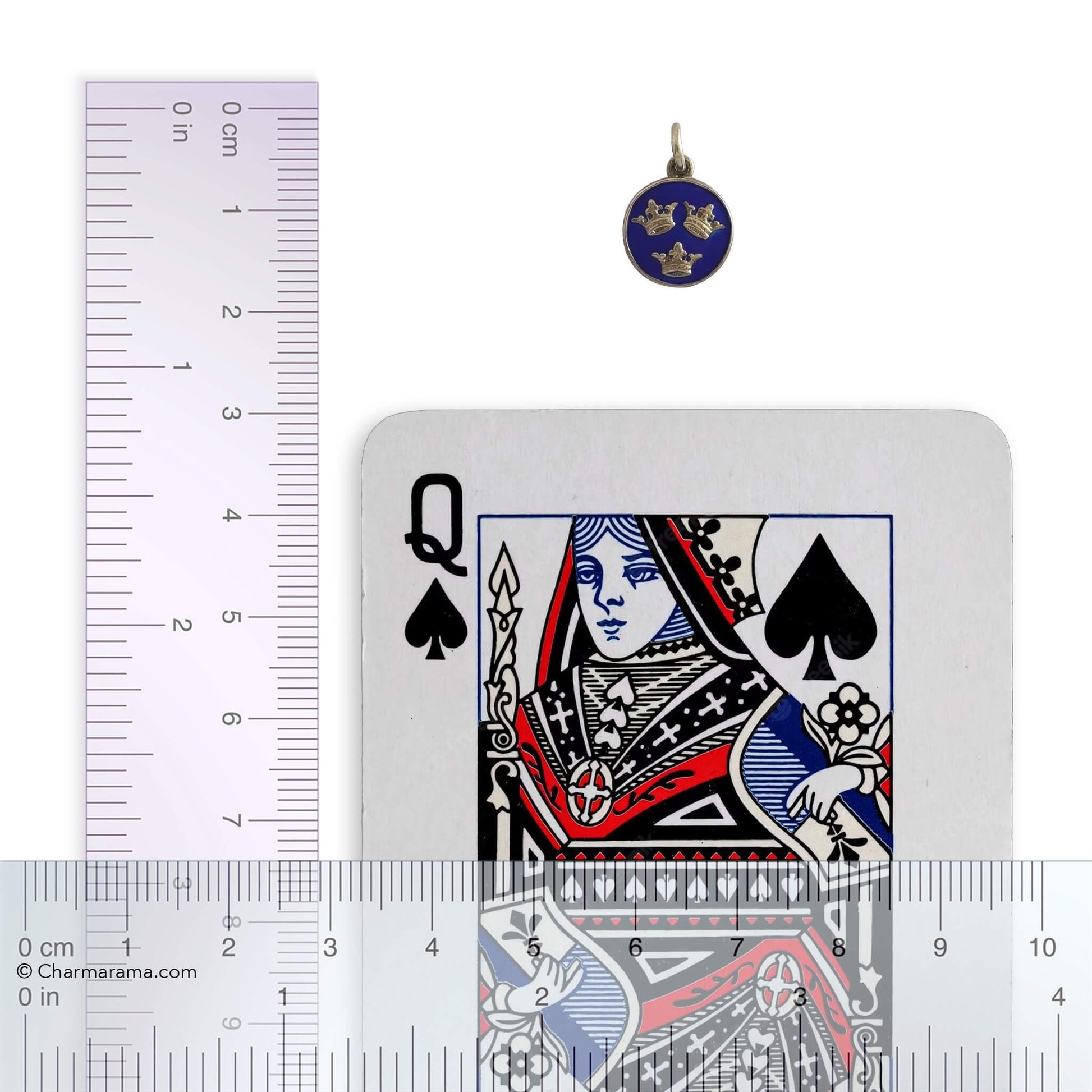 Playing card with Queen of Spades design, pendant, and ruler for scale on a white background