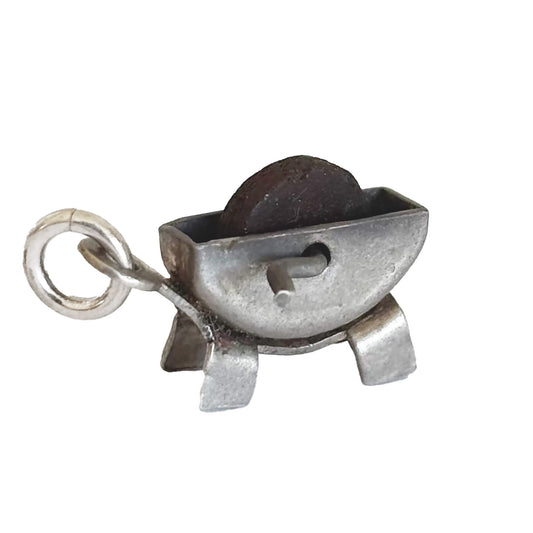 Vintage silver grindstone charm on a white background
