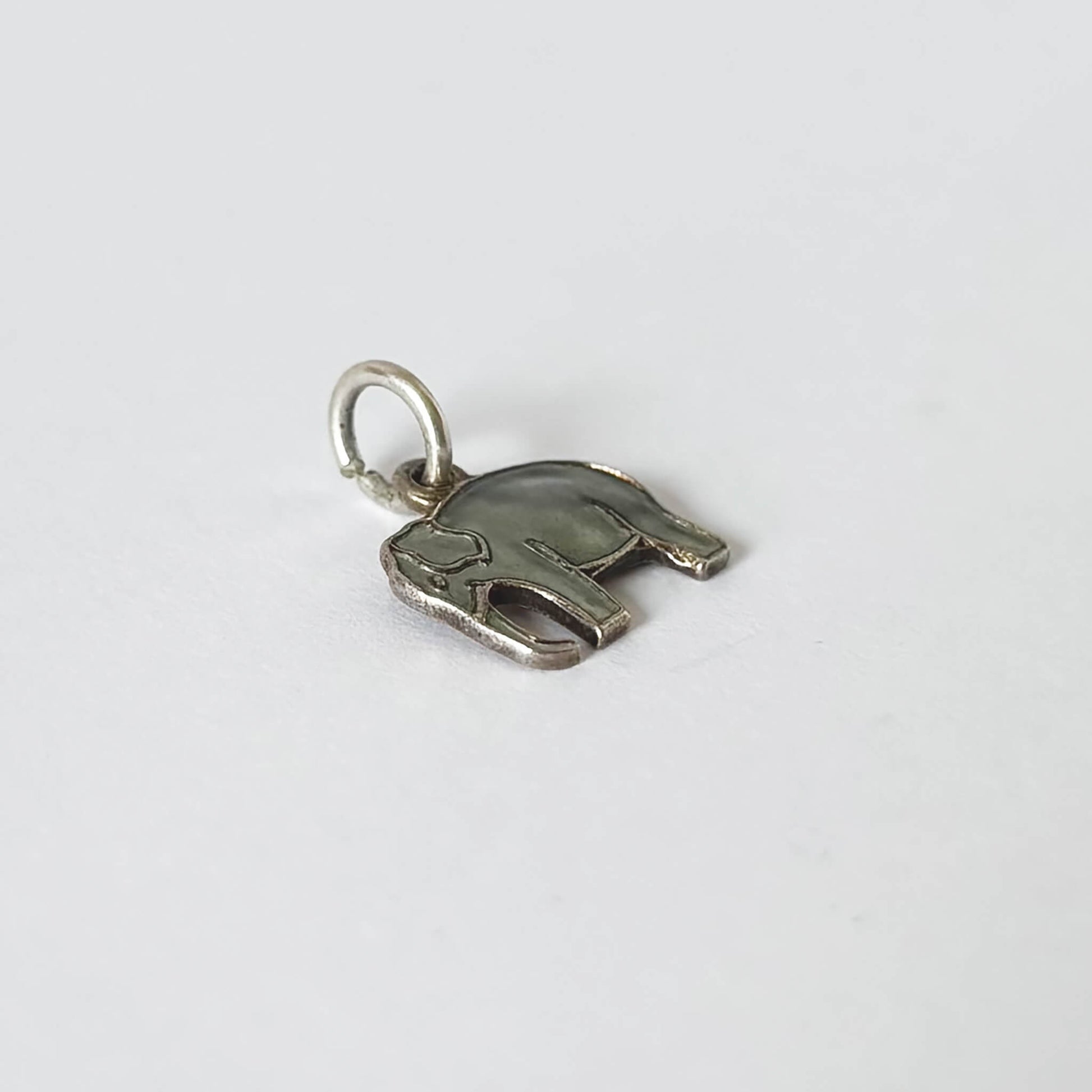 Silver elephant-shaped pendant on a white background