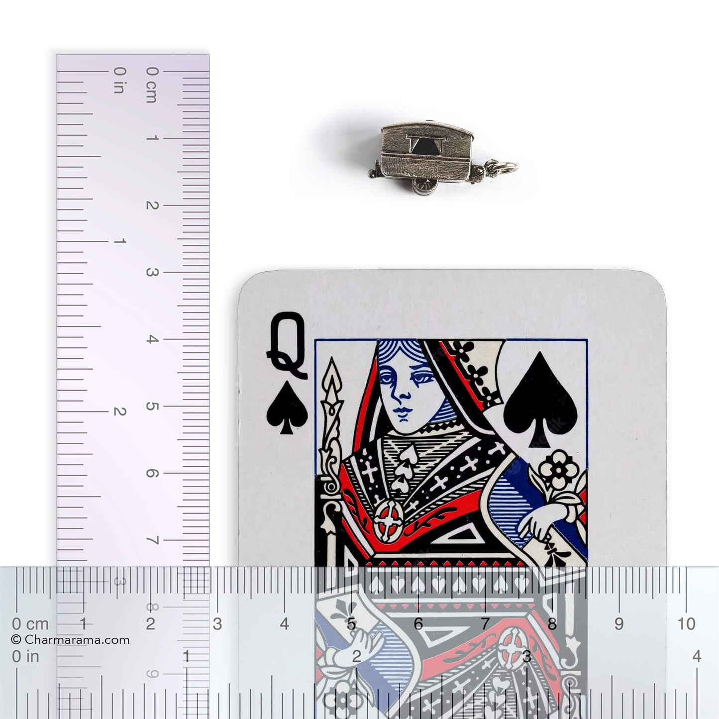 Vintage silver opening caravan charm with playing card and ruler on a white background.