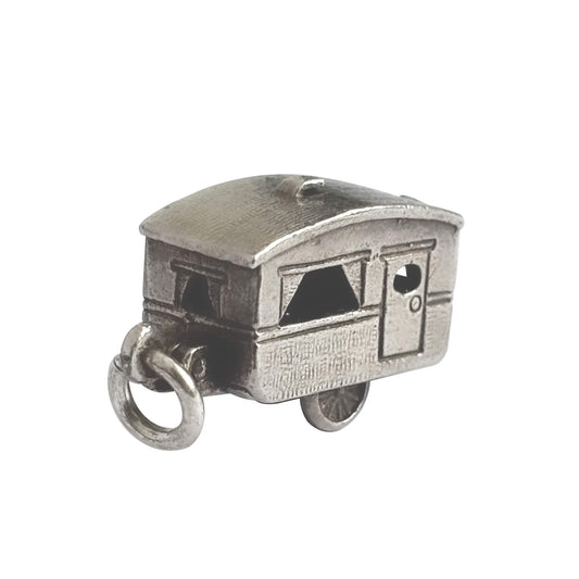 Vintage silver opening caravan charm on a white background.