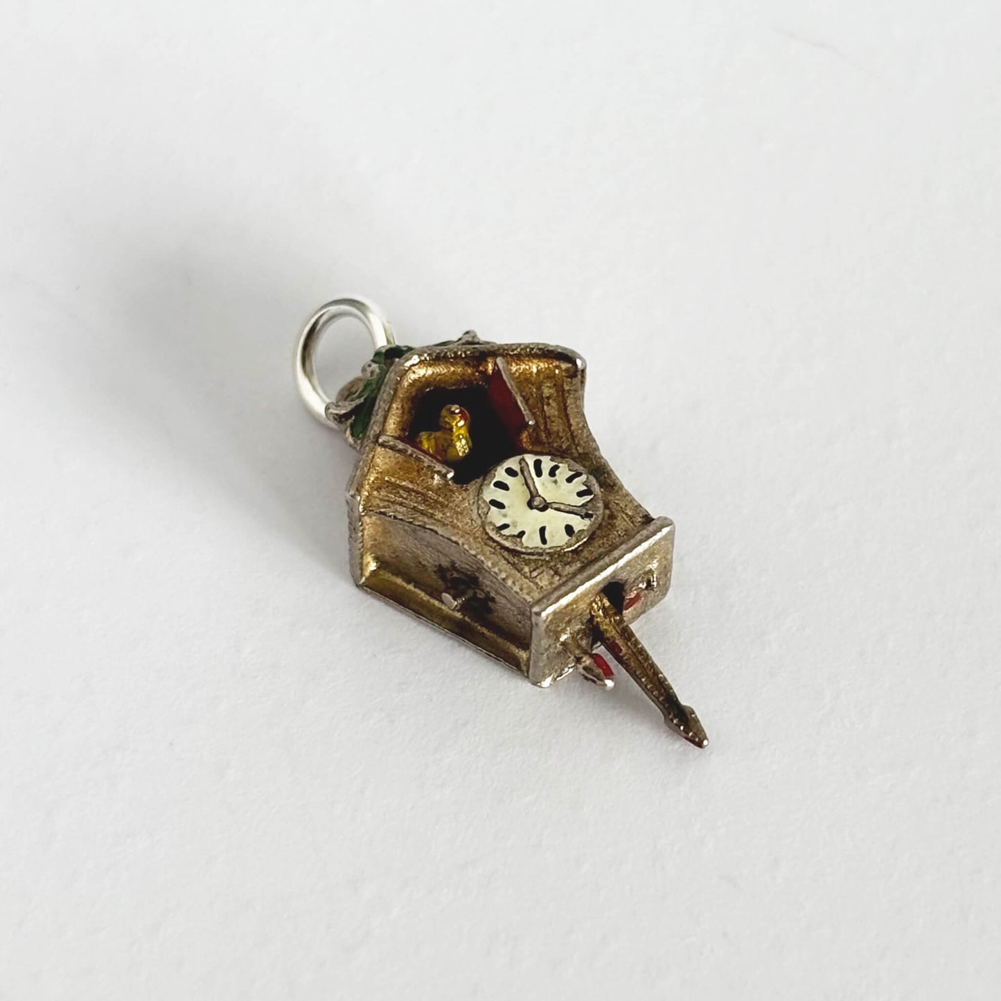 Vintage cuckoo clock charm on a white background