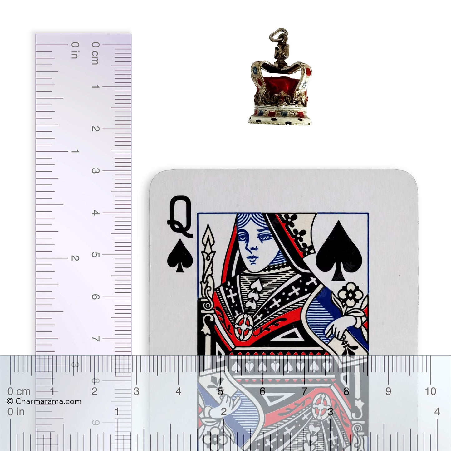 Silver and enamel crown pendant playing card and ruler for scale on a white background