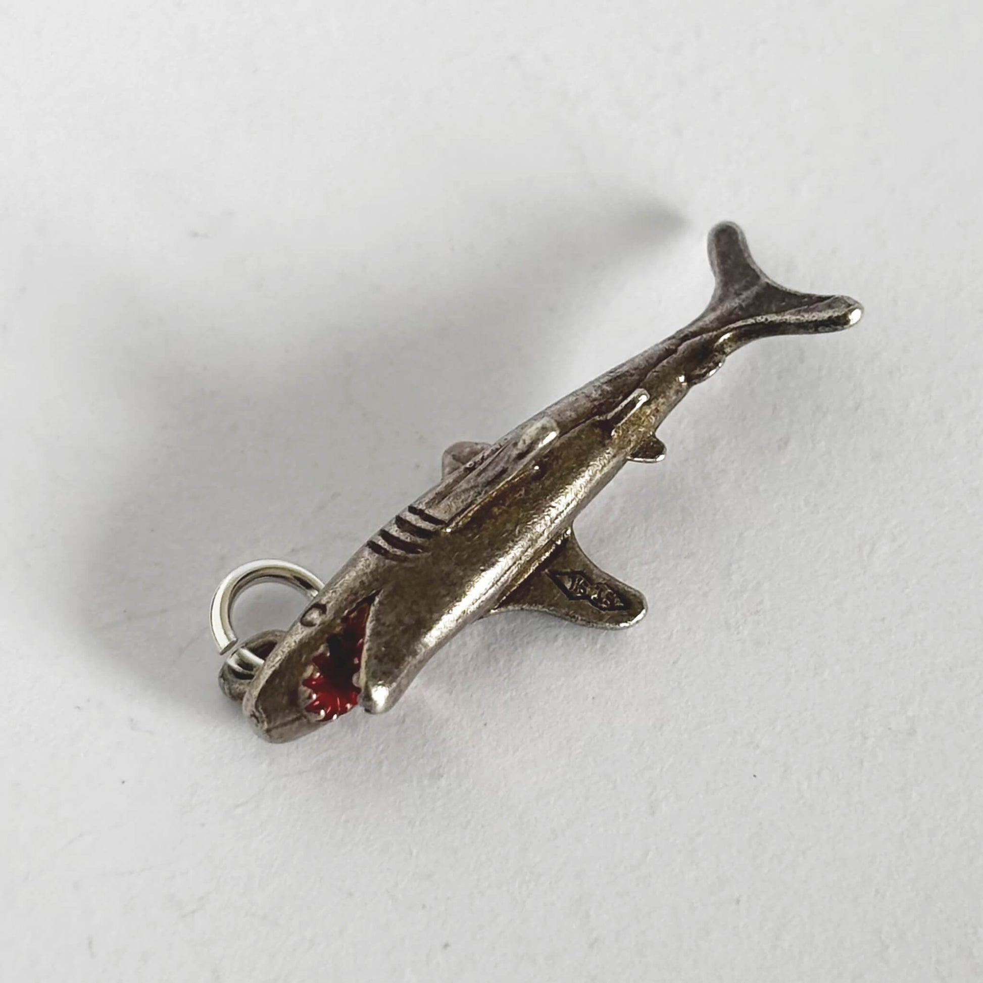 Silver shark charm on a white background