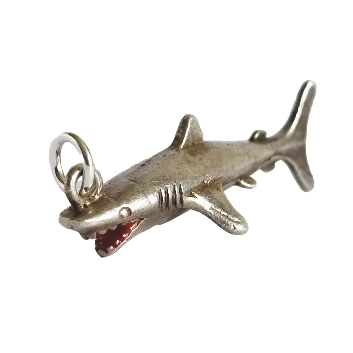 Silver shark charm on a white background