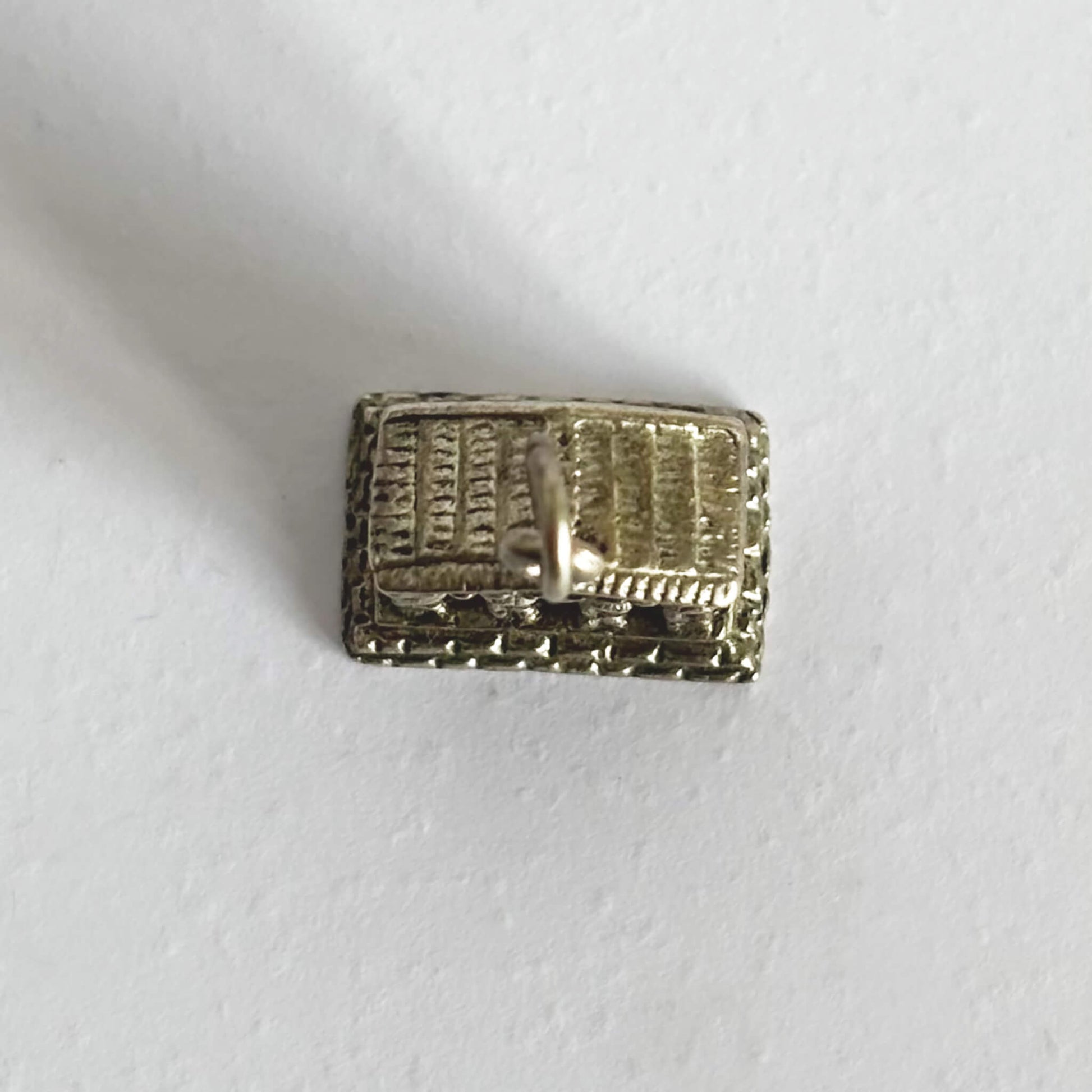 Silver greek  monument charm viewed from above on a white background