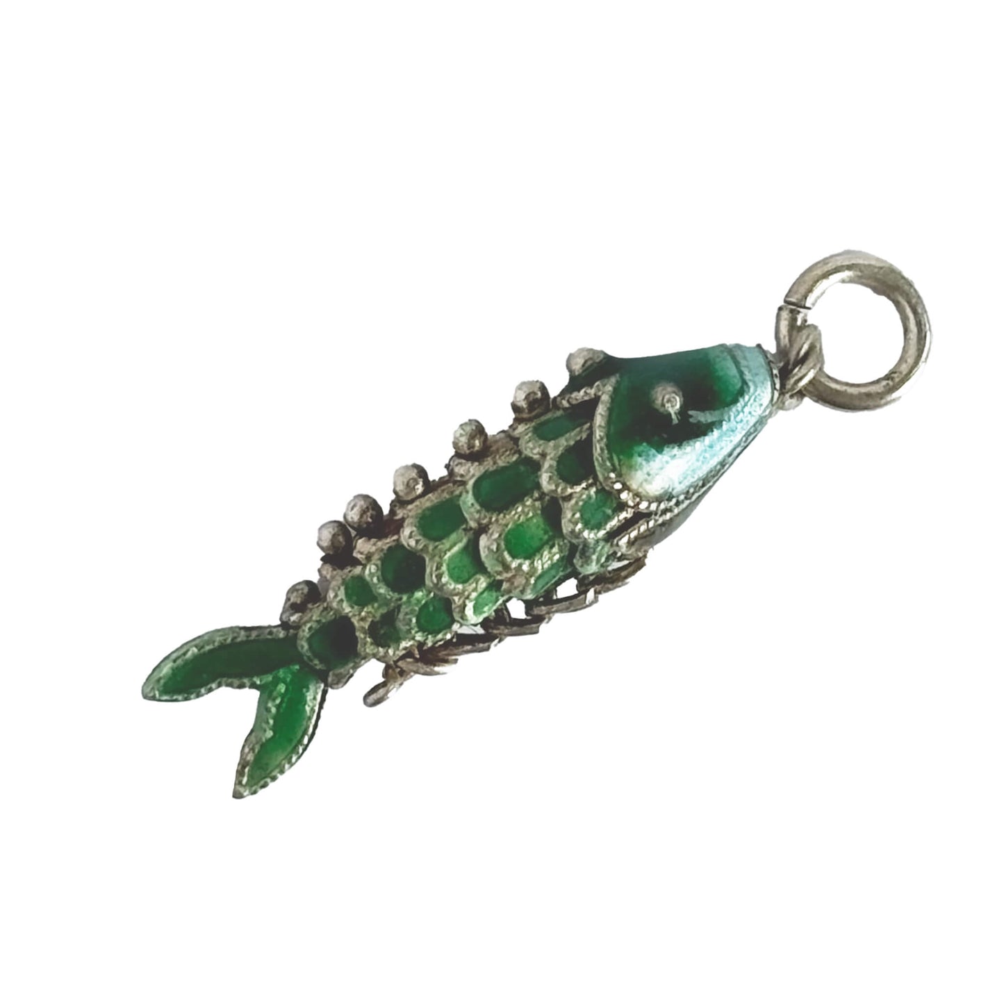 Vintage silver green enamel articulated fish charm on a white background.
