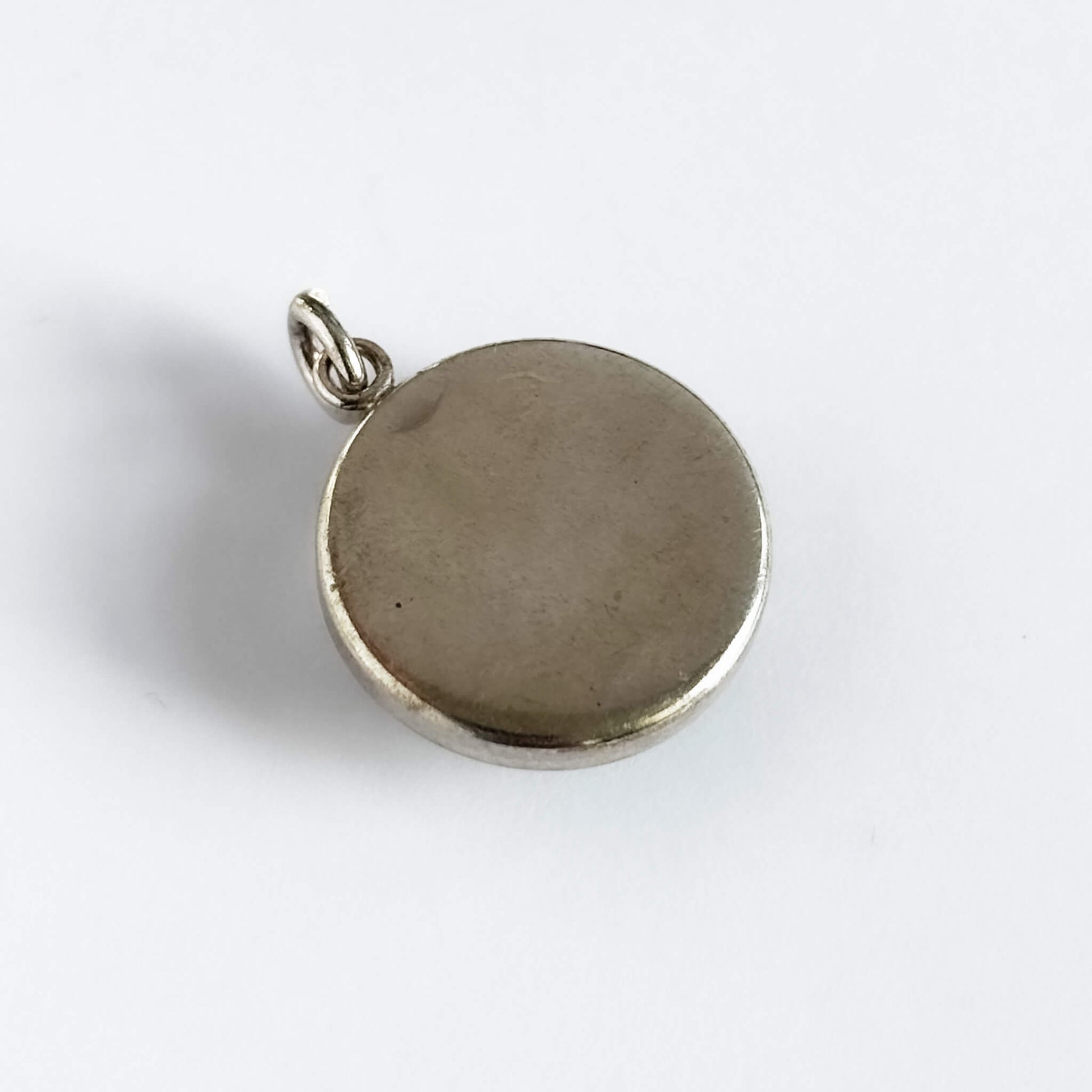 A vintage sterling silver reverse crystal pheasant charm on a white background.